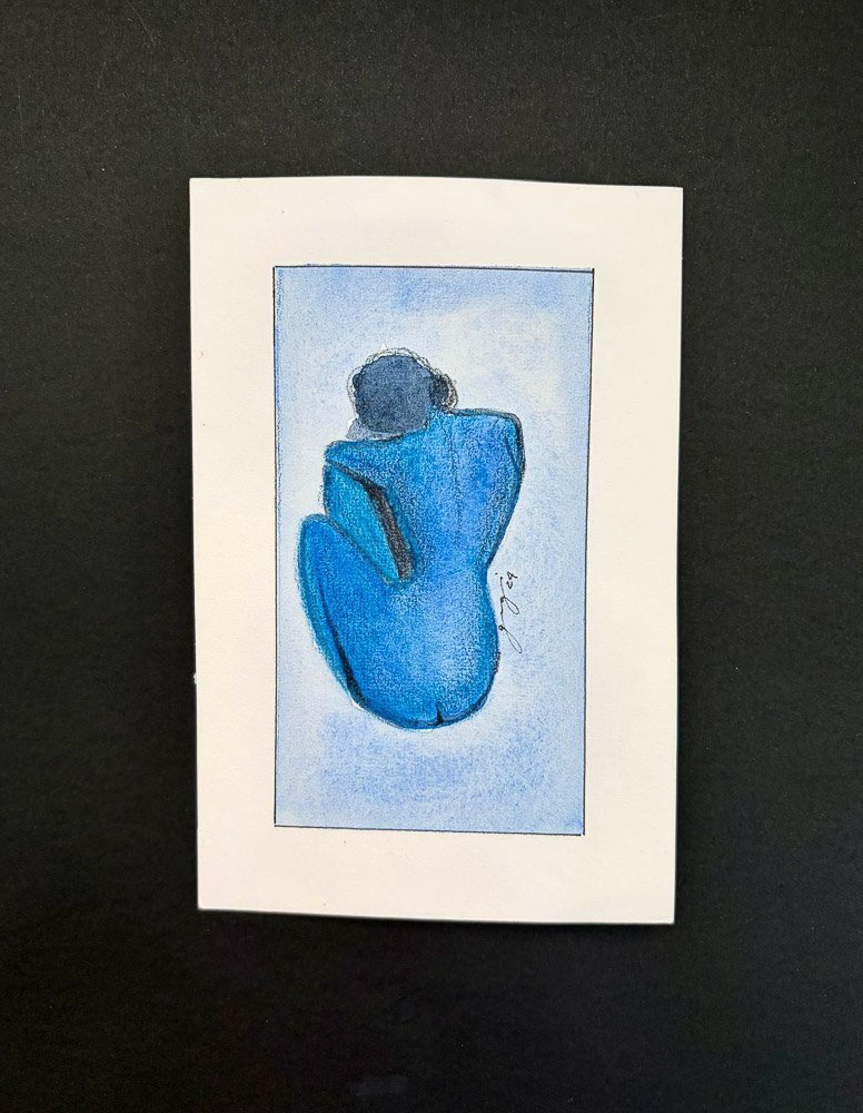 A watercolor painting of a woman sitting with her back facing the viewer, depicted in shades of blue and black, signed by the artist in the bottom right corner.