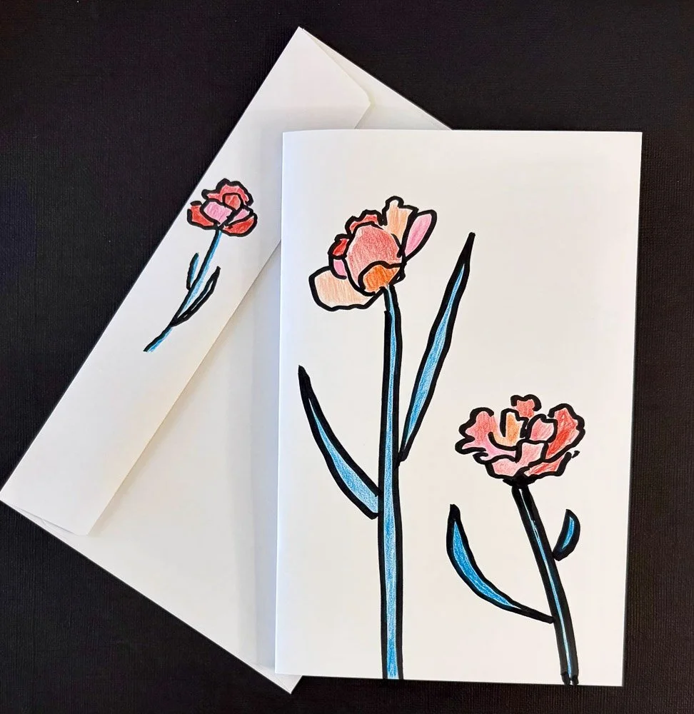 Hand-drawn floral illustration on white paper, featuring three pink flowers with blue stems and black outlines, placed on black background.