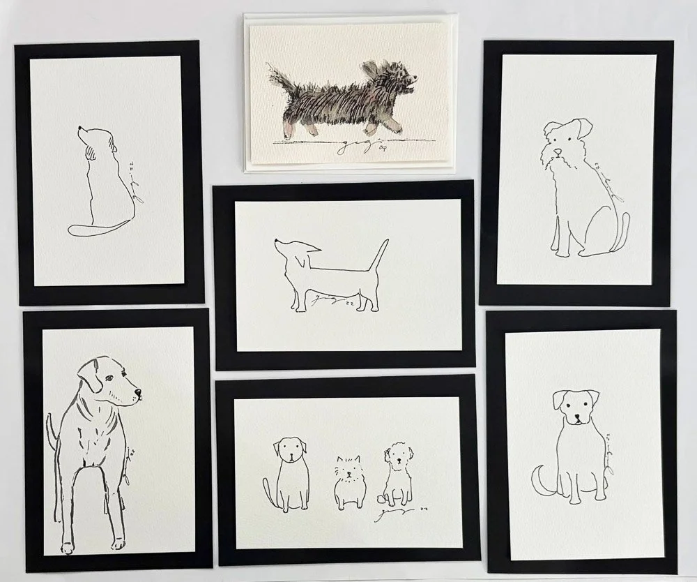 Collection of seven framed minimalist dog sketches and one embroidered dog portrait on a white wall.