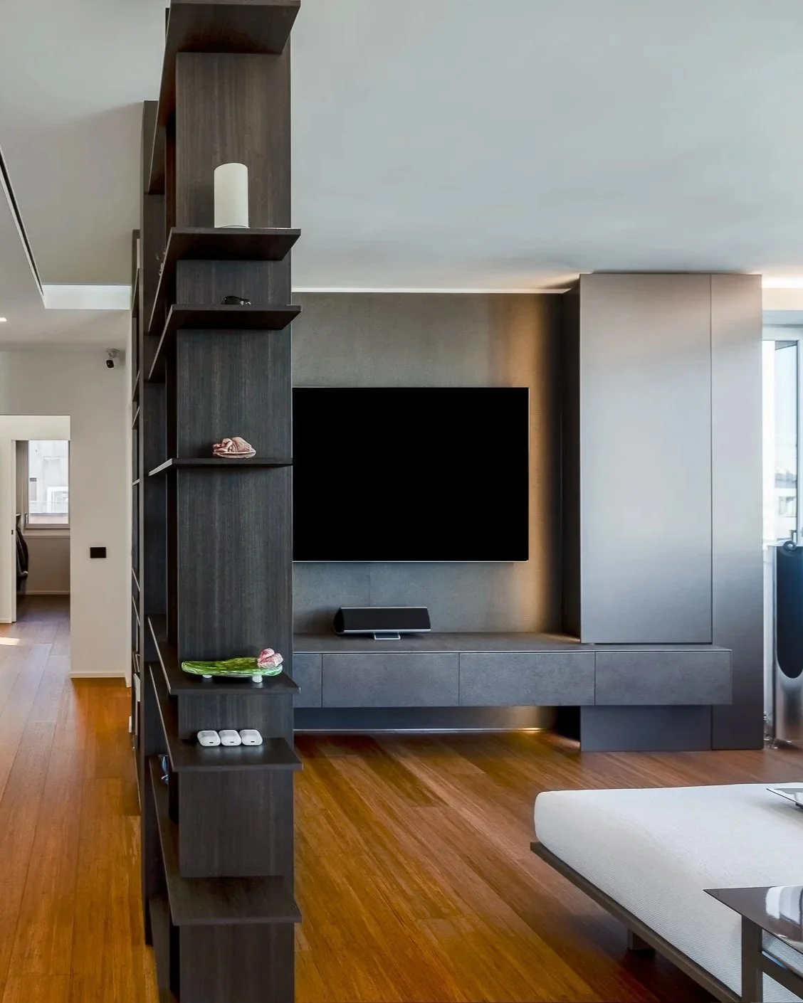 Interno di un soggiorno moderno con parete attrezzata grigia e TV a schermo piatto