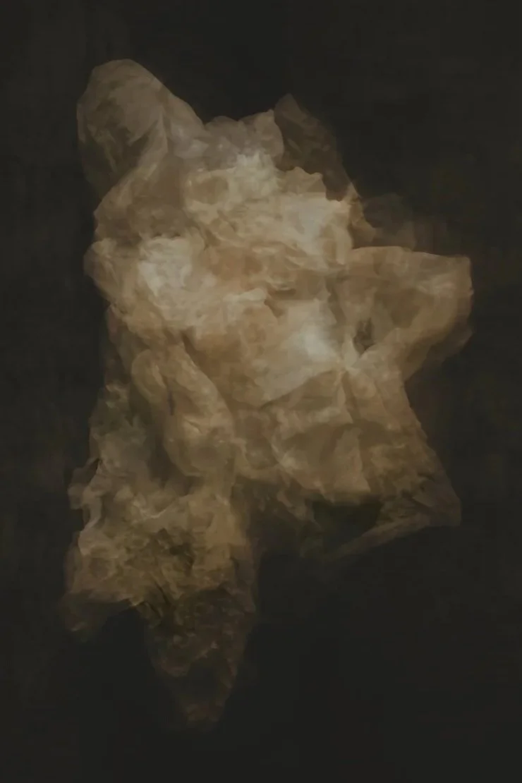 A rock formation with a shape resembling a woman's face, set against a dark background.