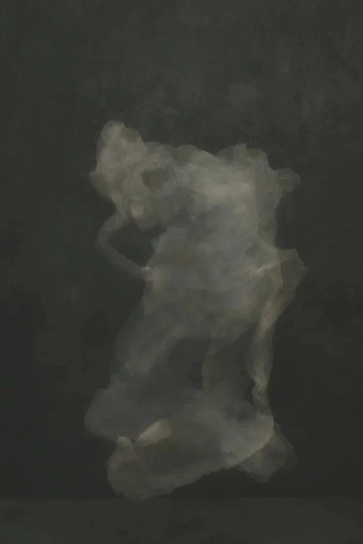 Blurred image of a person in a crouching pose against a dark background.