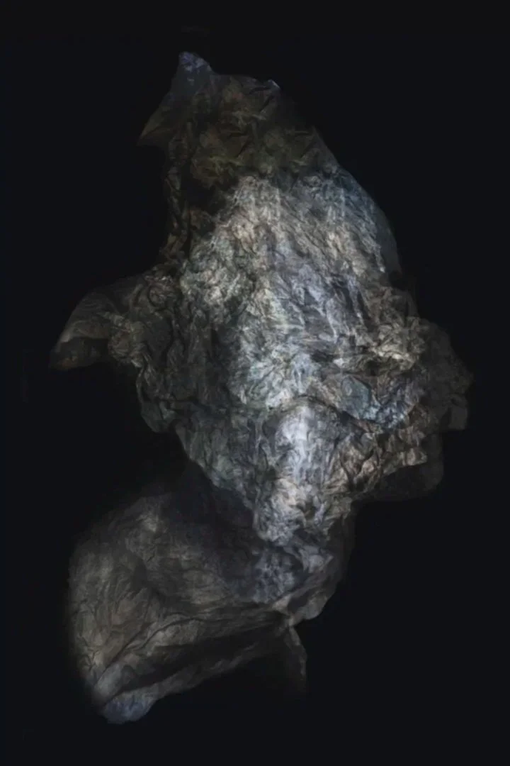 A crumpled piece of gray and silver metallic material on a black background.