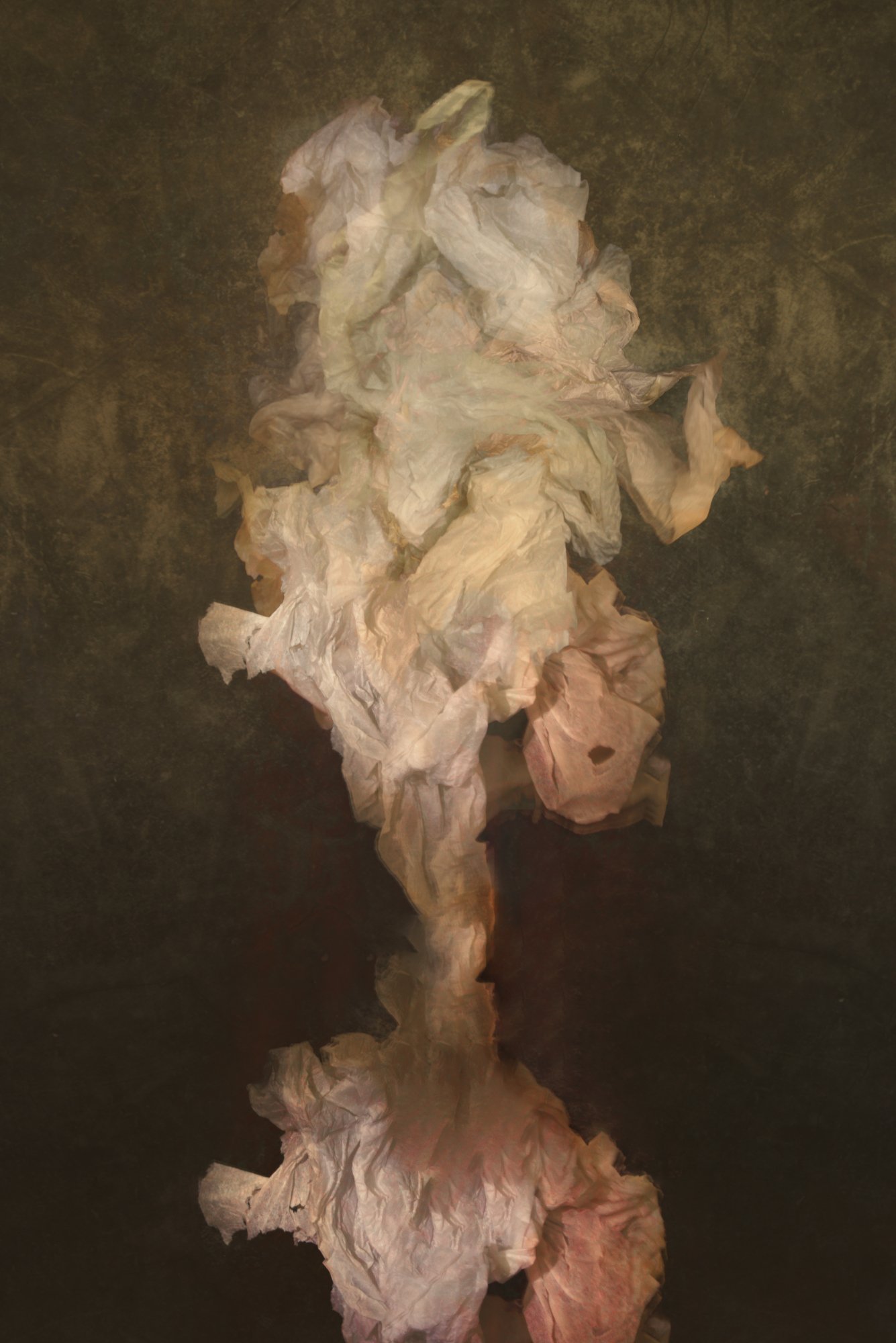 A pile of crumpled, wrinkled paper towels on a dark surface.