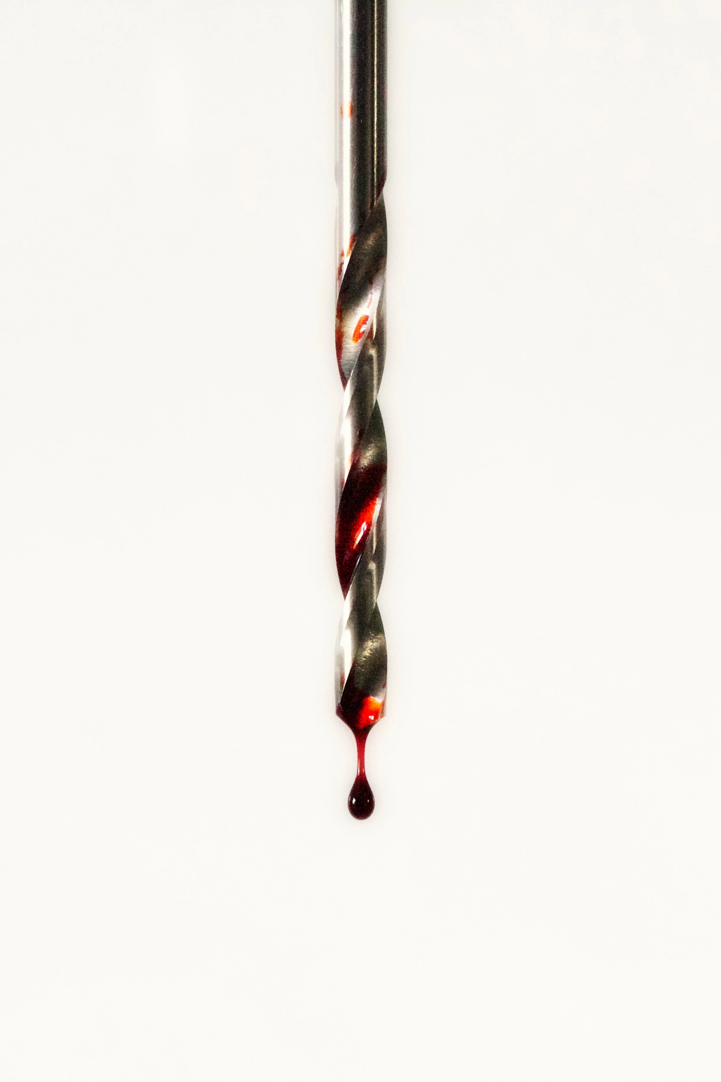 A paintbrush with red and black paint dripping from the tip, against a plain white background.