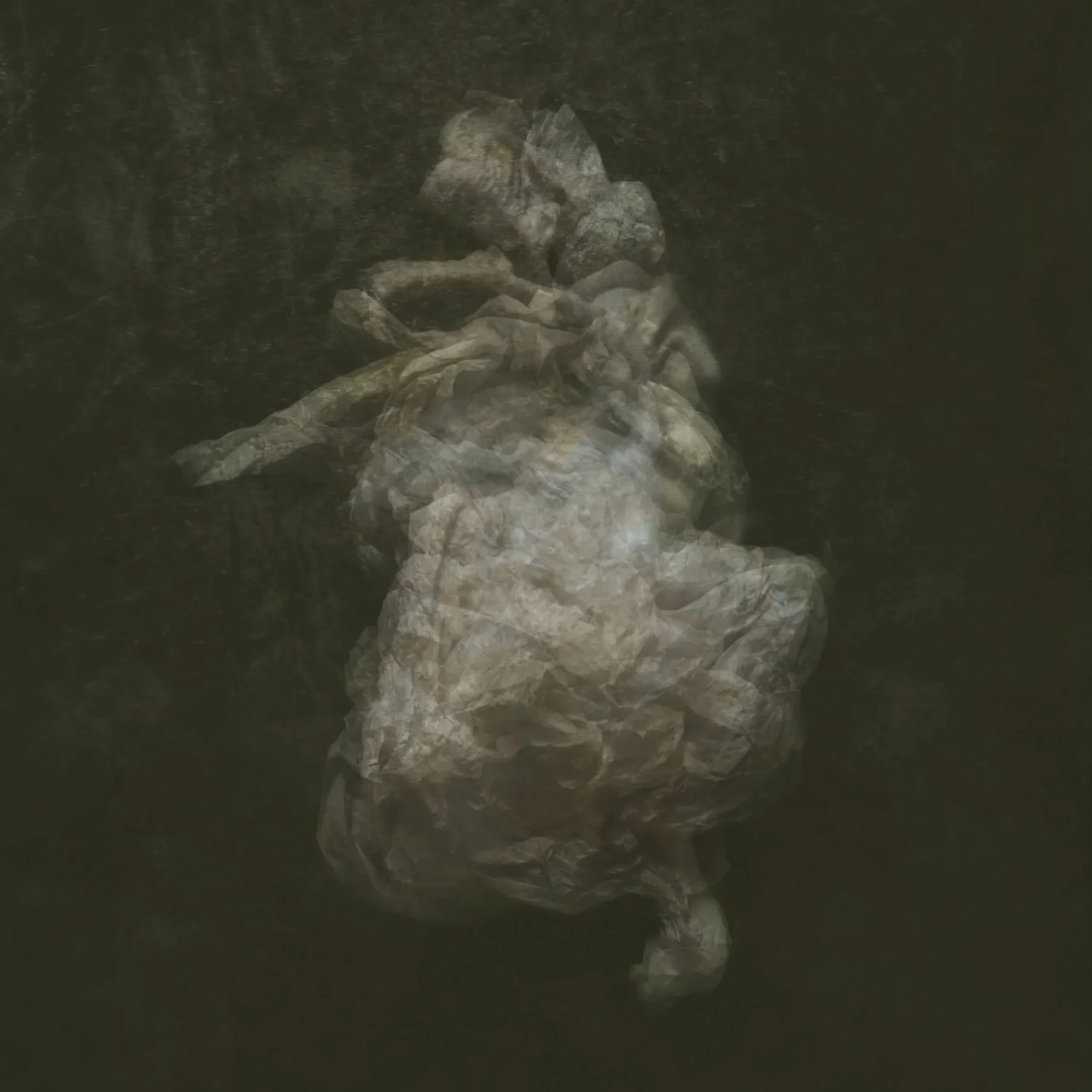 A pile of crumpled paper on a dark surface with a blurry background.