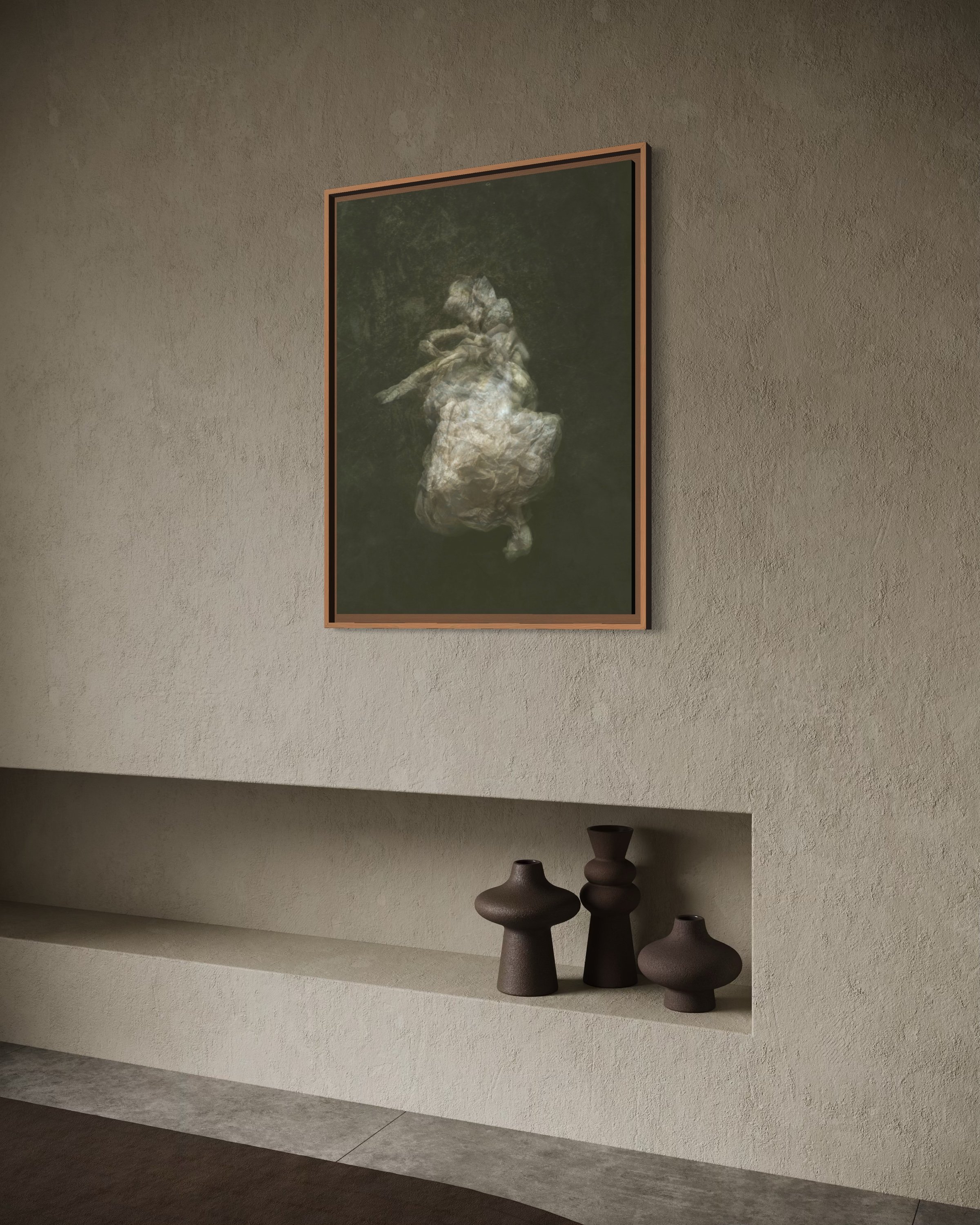 A framed art piece on a beige textured wall, depicting a figure made of rocks or stone in a natural outdoor setting. Below the artwork, there is a built-in shelf with four decorative vases of varied shapes and sizes in dark earthy tones.
