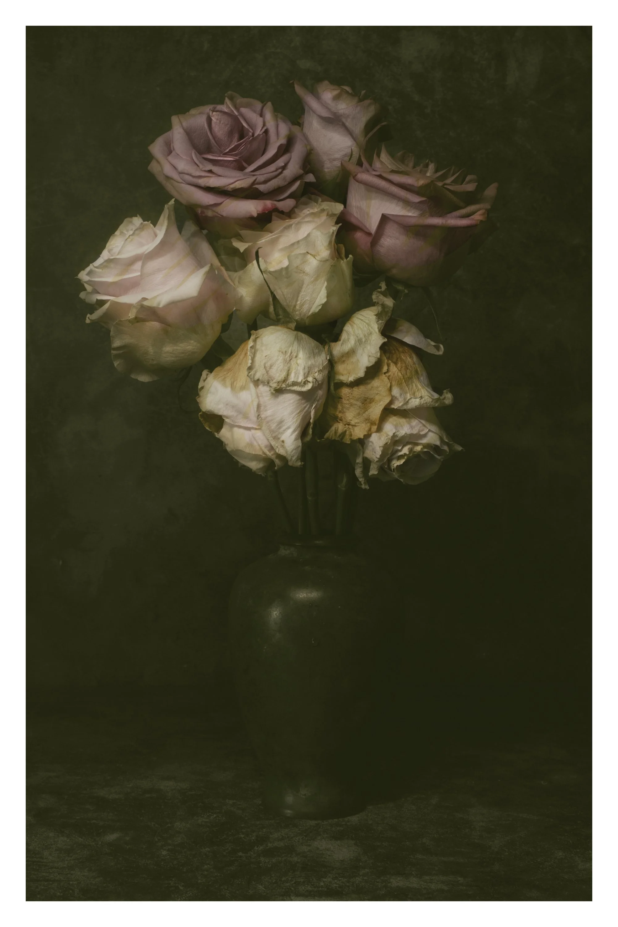 A bouquet of wilted and dried roses in a vase against a dark background.