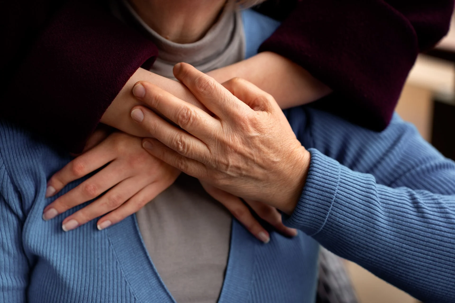arms wrapped around lady in blue jumper
