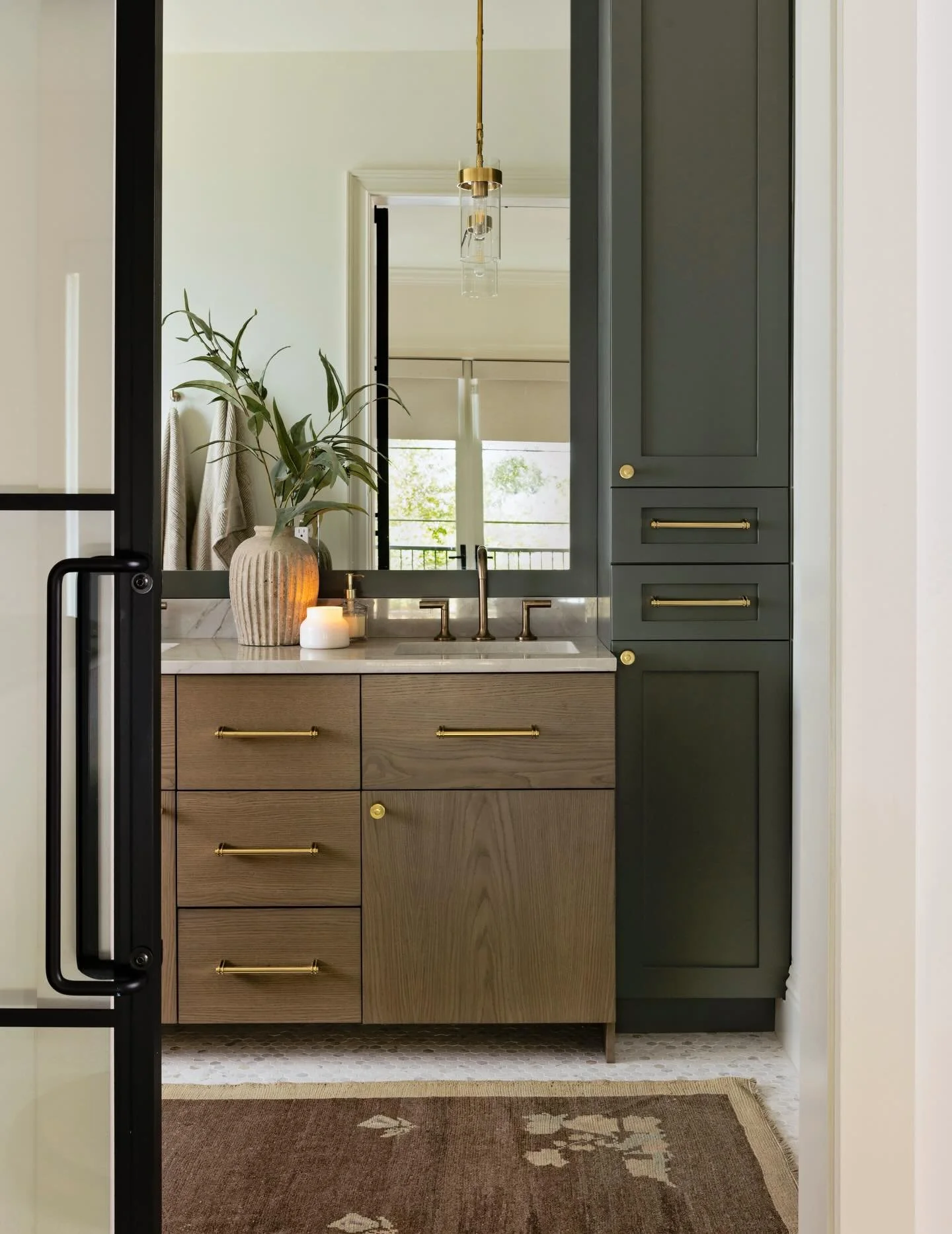A primary bath that feels like a boutique retreat. Vintage rug, pendant lighting and warm wood with deep green cabinetry. 
View the full gallery of Lake Catherine on the website.

Photography @nativehousephotography 

#interiordesign #bathroominspira