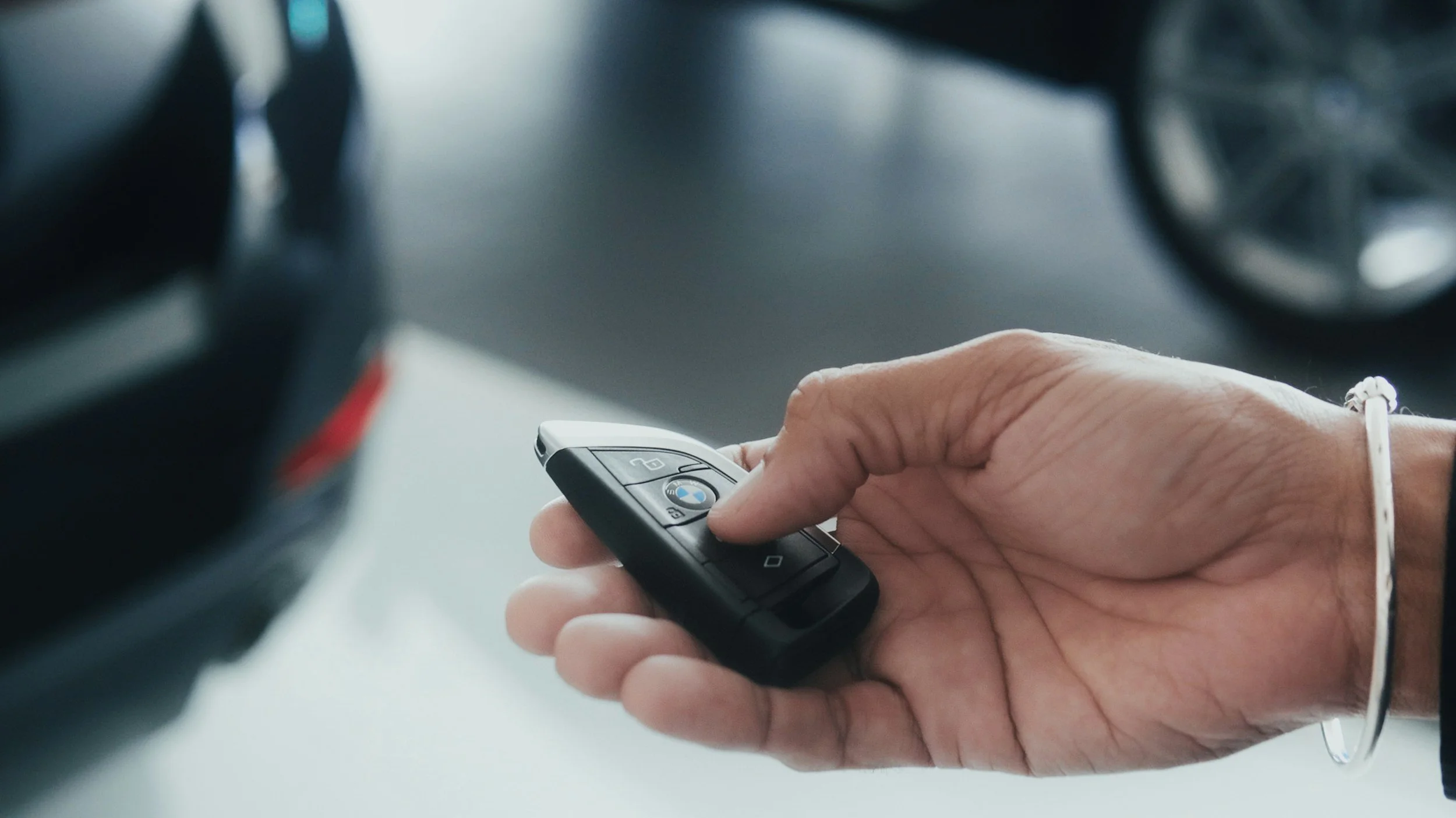 Person holding a BMW car key in their hand, going to his car that has been just serviced correctly