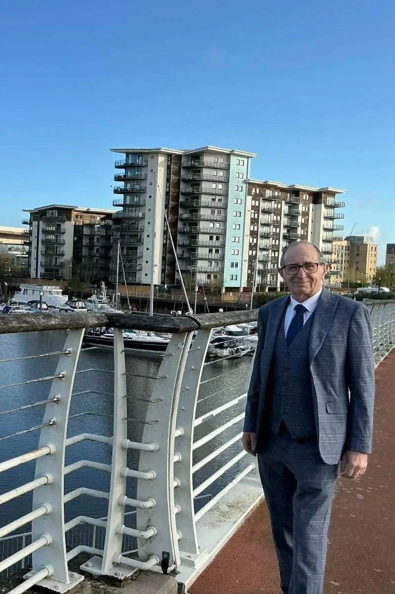David Keene, qualified therapist, standing outdoors with city skyline behind him