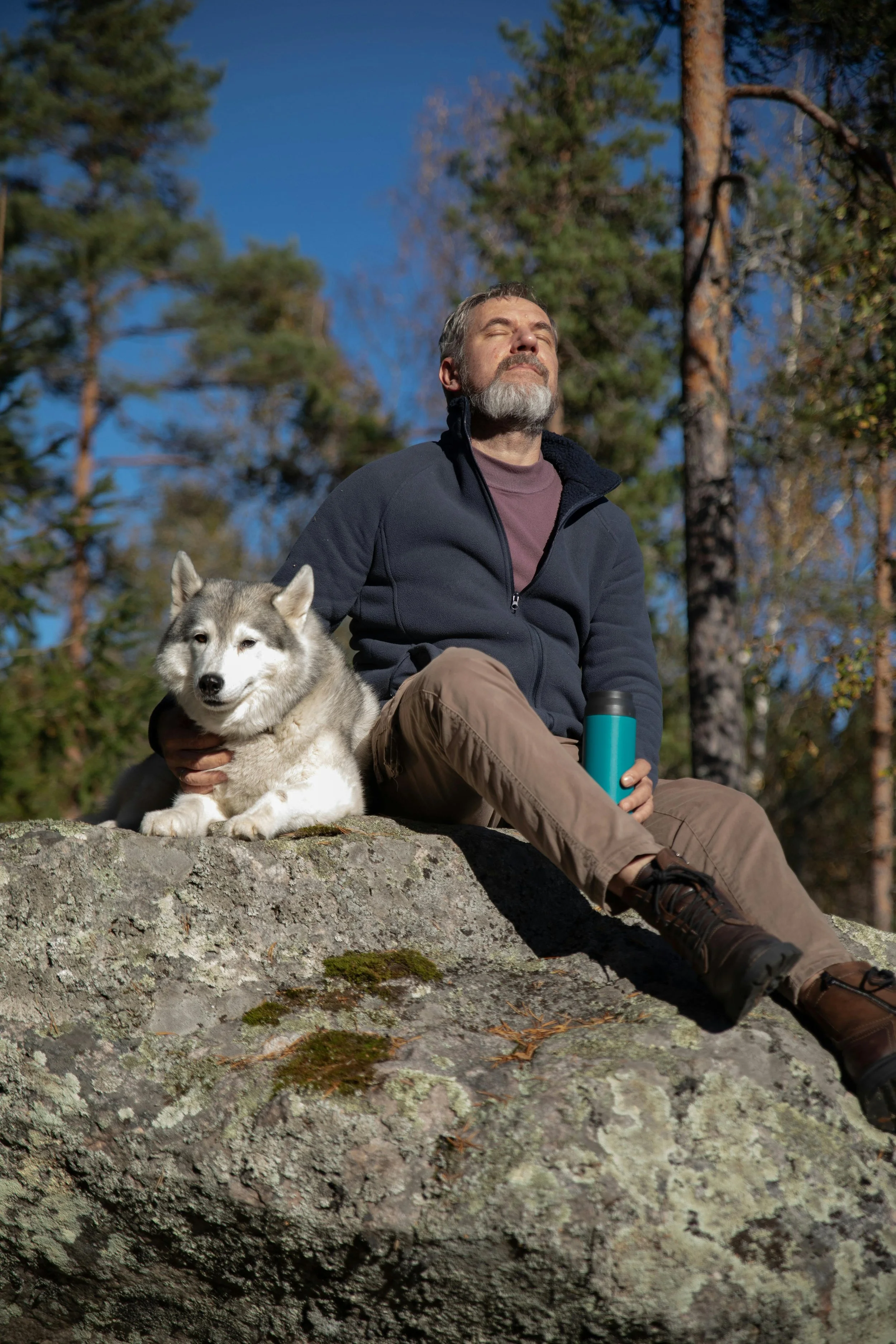 Happy man walking his dog on a countryside hike representing wellbeing and balance