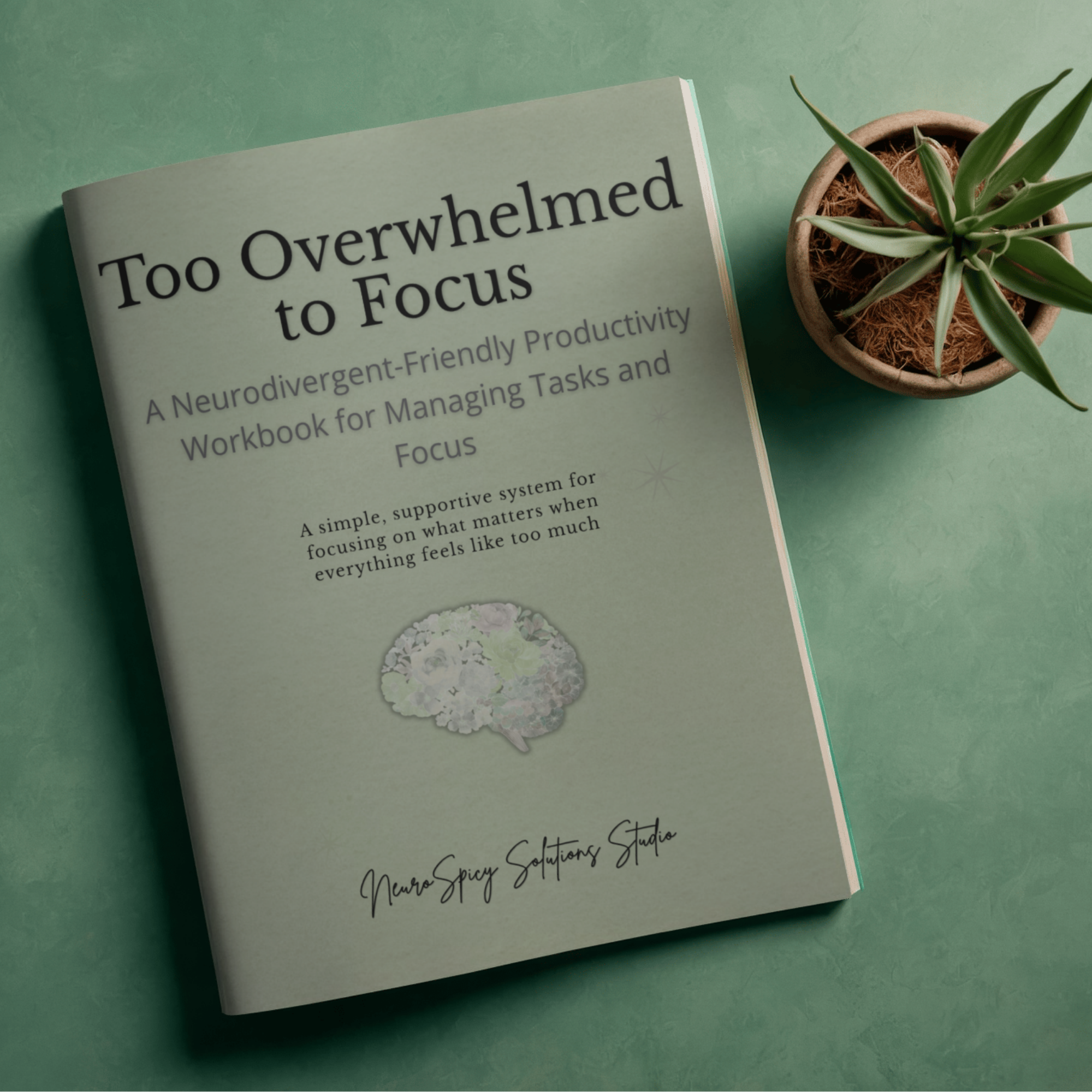 A book titled 'Too Overwhelmed to Focus' and a potted plant on a green surface.