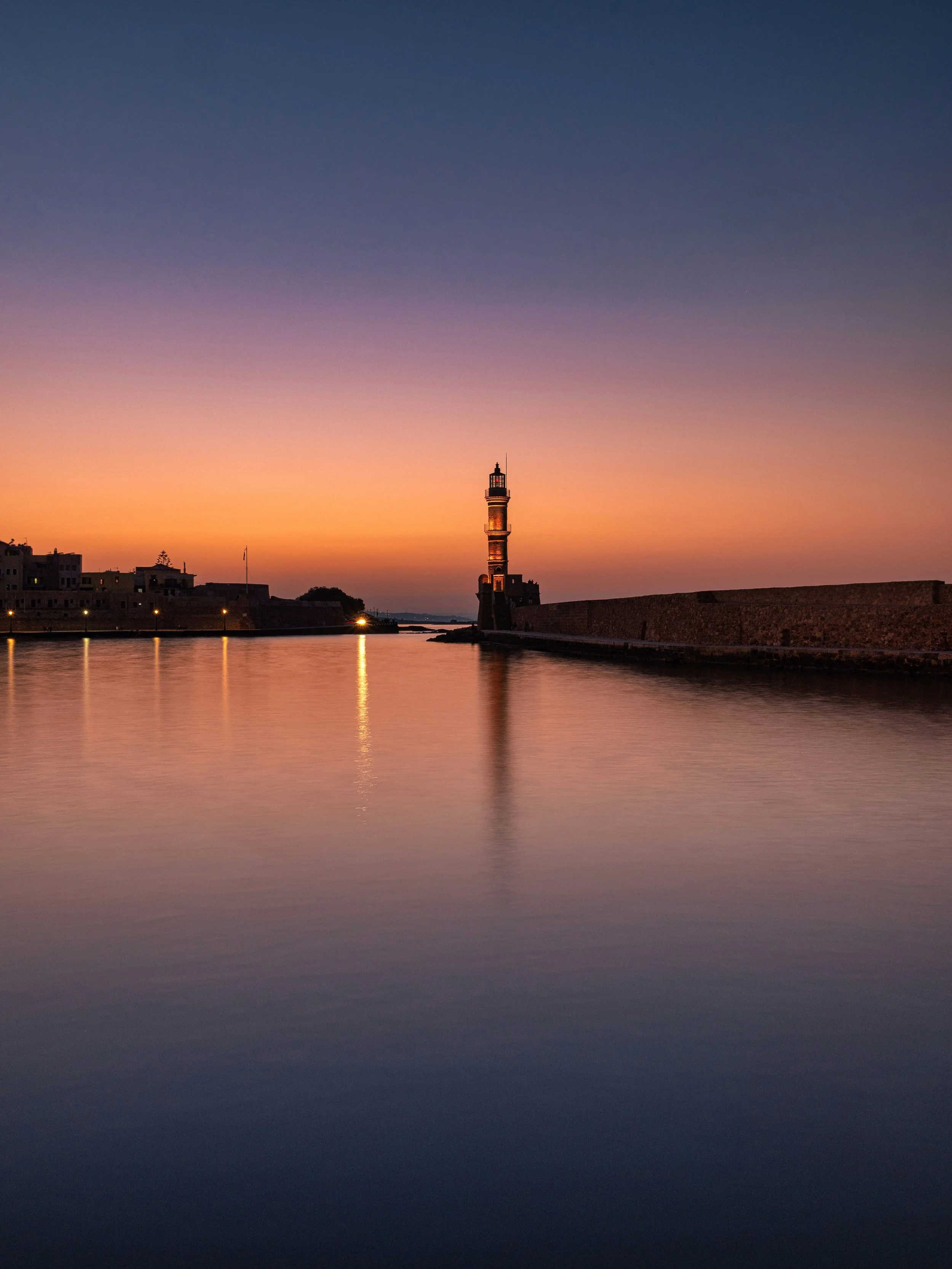 Calm lighthouse and harbor walls.