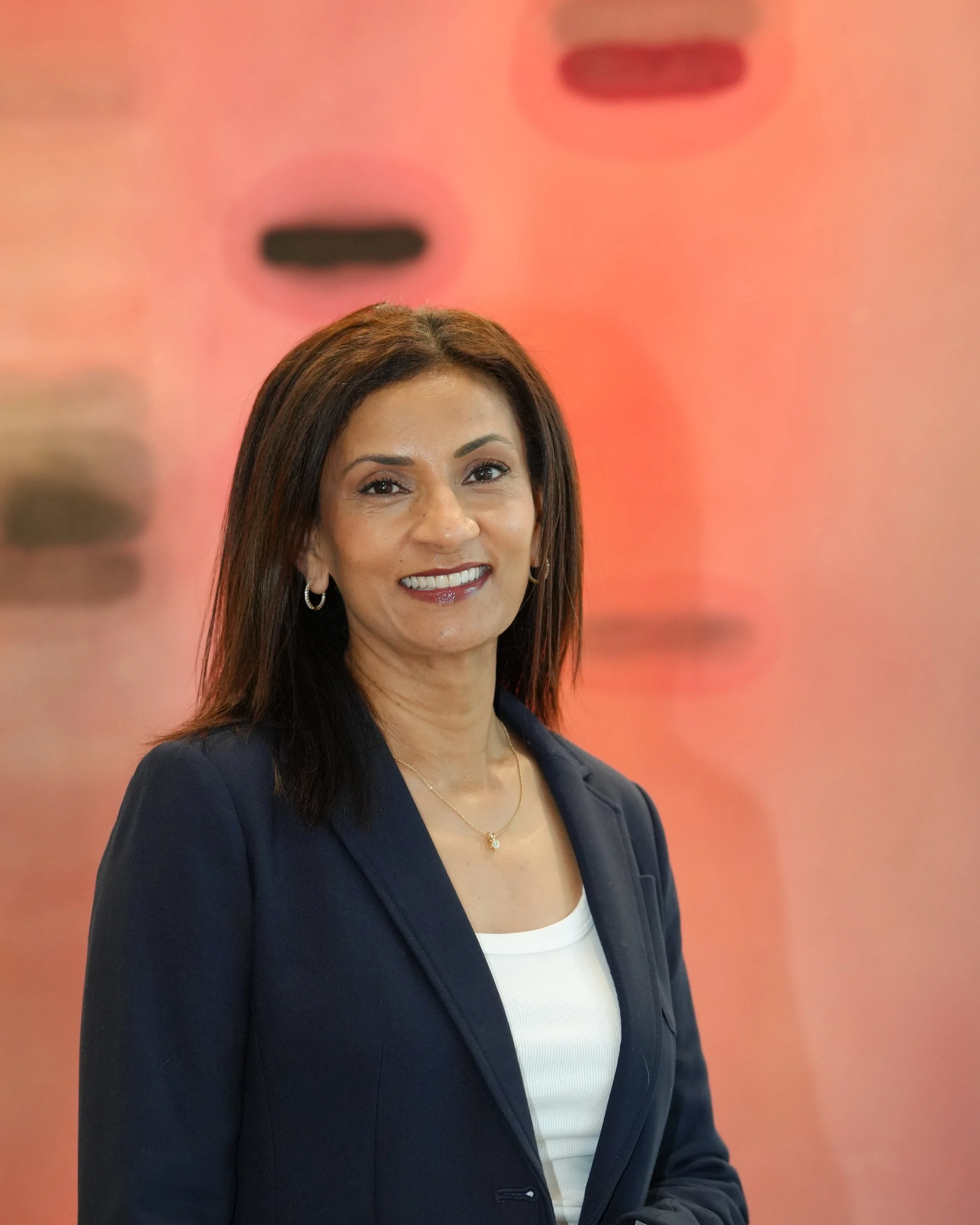 Poornima professional headshot - pink backdrop.