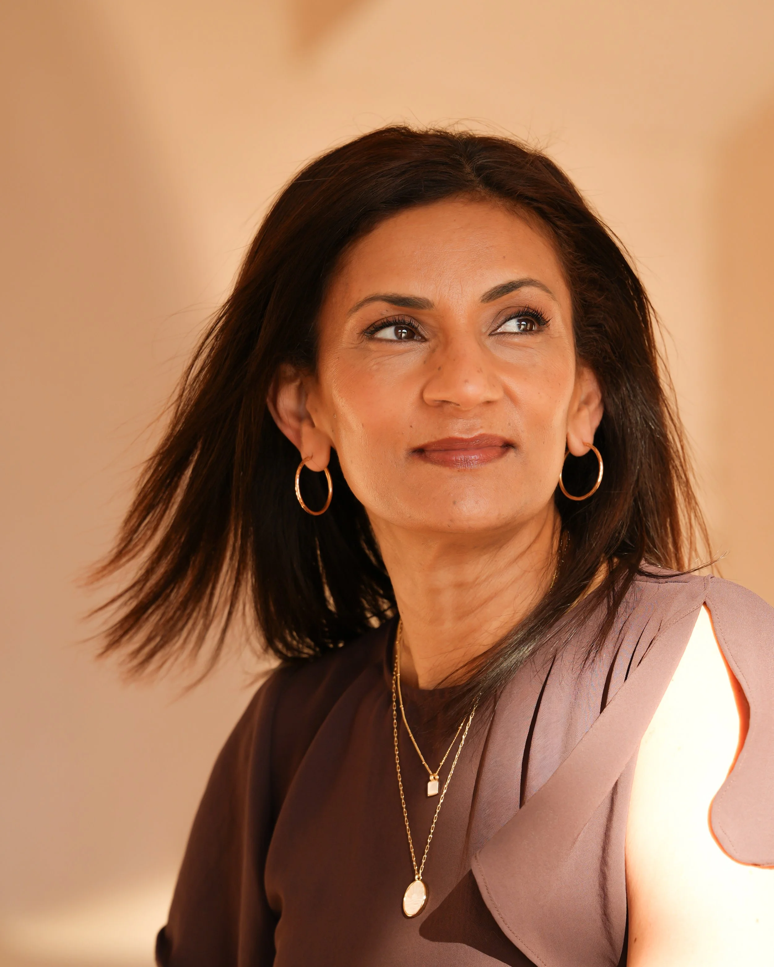 Poornima professional headshot - sunlight reflection.