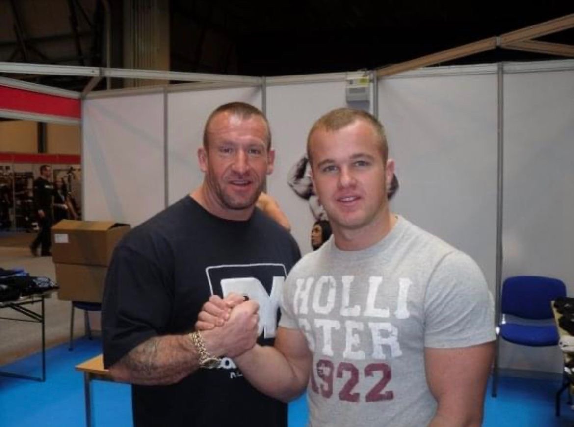 two men holding hands posing for the camera
