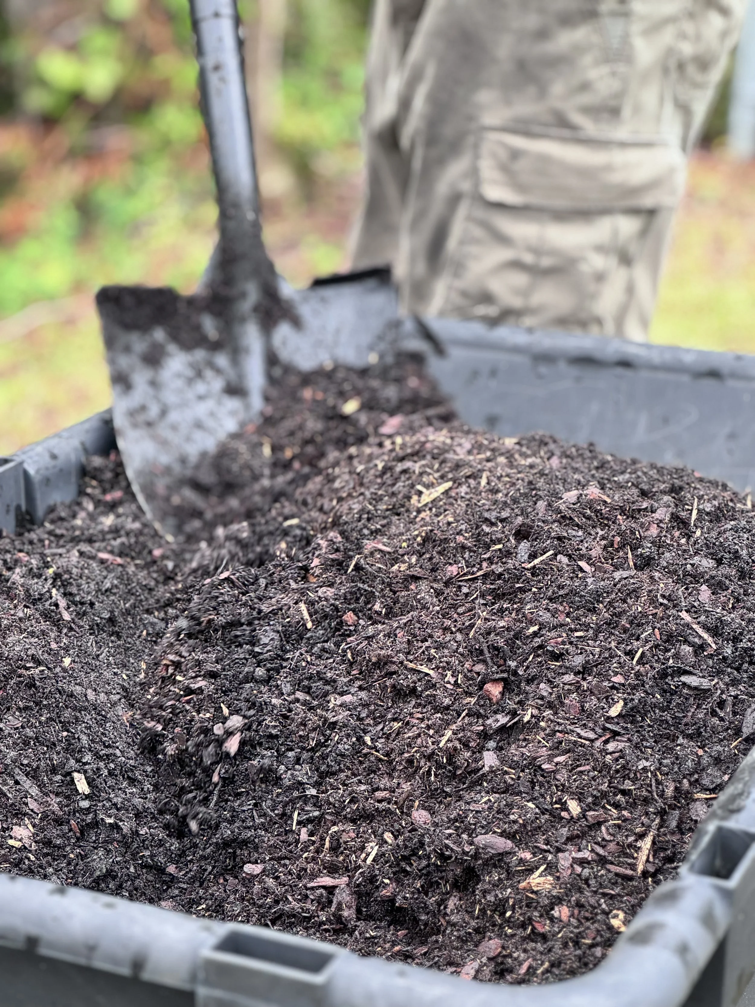 Soil inside a gardening container, captured from a close-up angle.