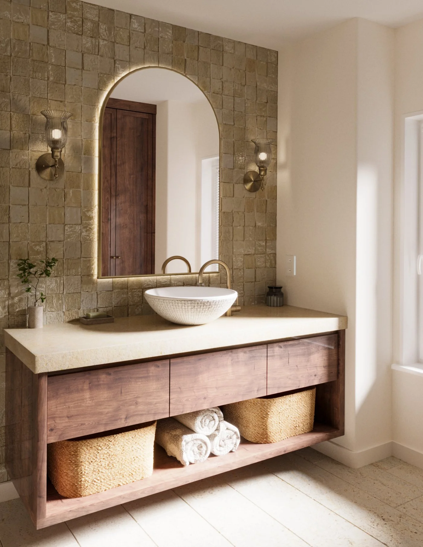 Bathroom vanity with a round vessel sink, mirror with backlighting, two wall sconces, towels stored below, and beige stone tiles on the wall.