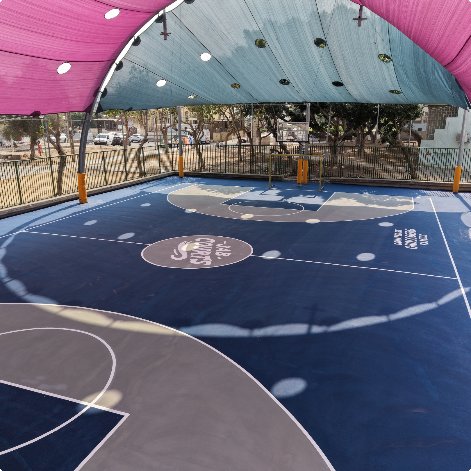 Renovated outdoor basketball court by JAB Courts featuring modern design and safe space for youth development and play