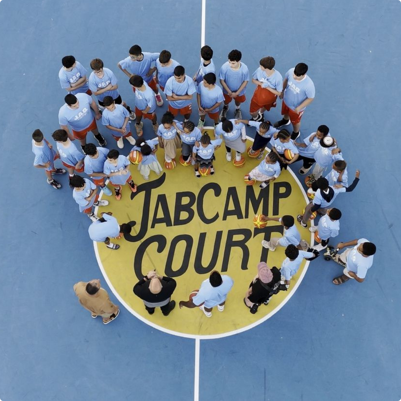 Overhead view of kids gathered at JAB Camp Court showing community youth basketball program and leadership development