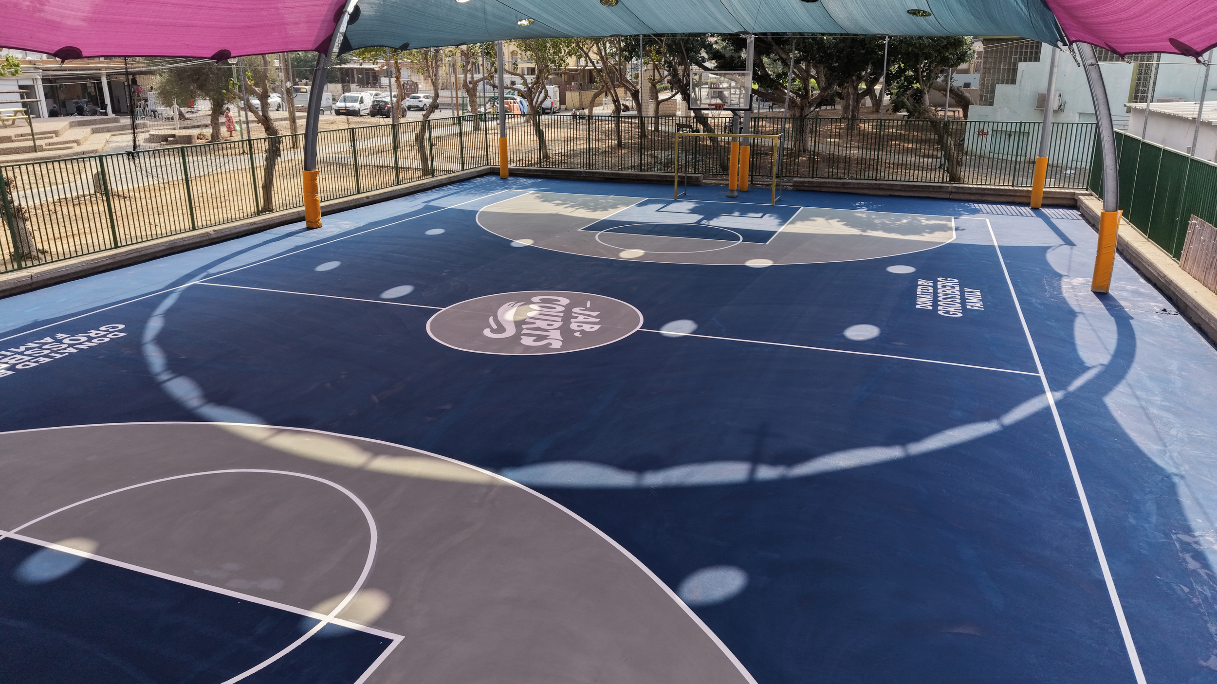 Renovated outdoor basketball court by JAB Courts featuring modern design, vibrant colors, and a safe space for youth and community use