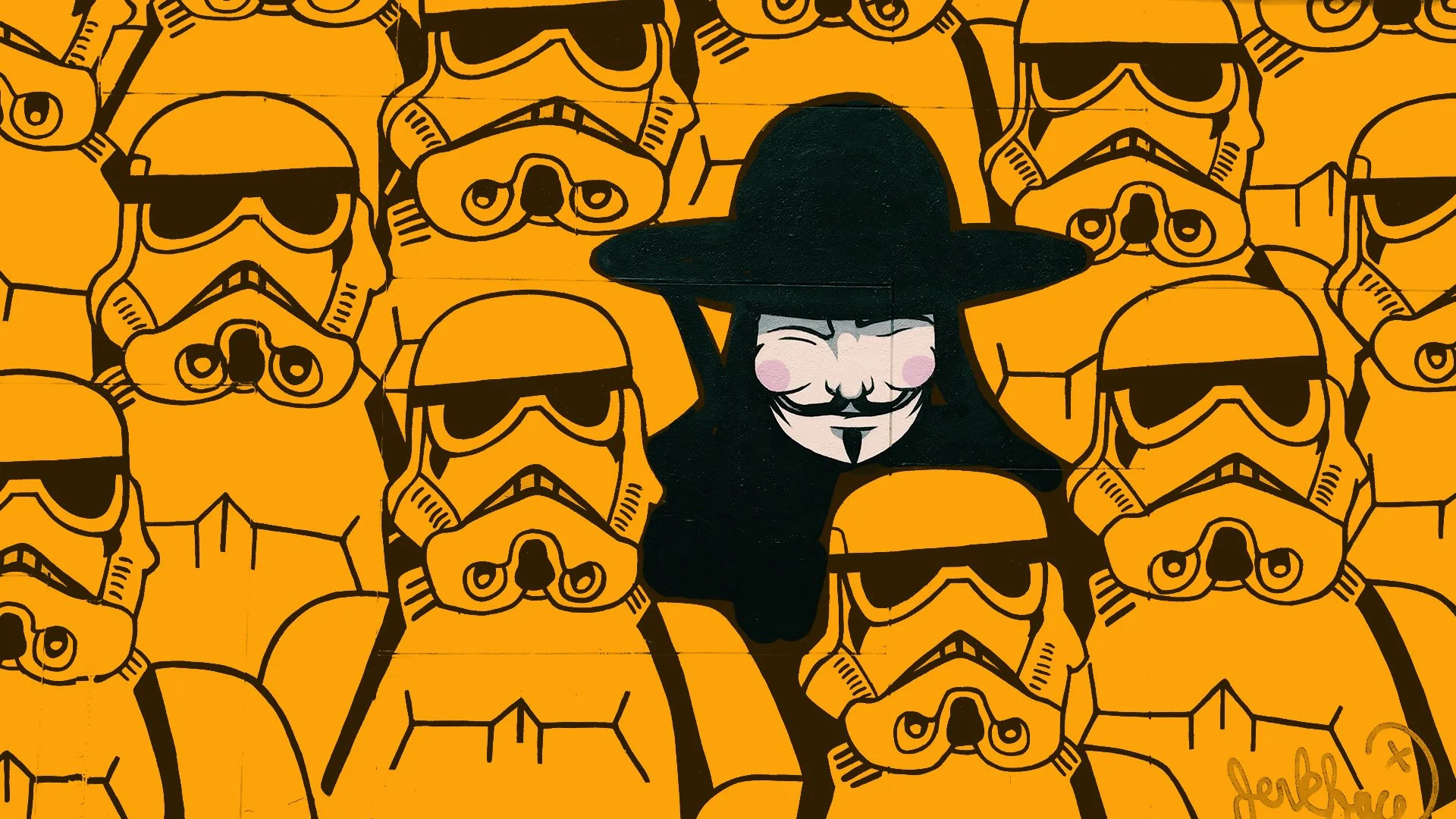 Street art mural of a smiling Guy Fieri wearing a black sombrero, surrounded by a repeating pattern of Darth Vader's stormtrooper helmets with sunglasses on an orange background.