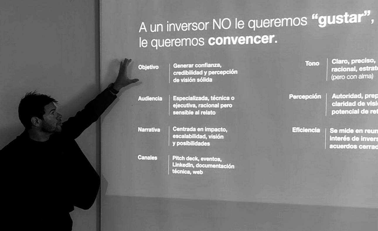 Hombre de traje negro señalando una presentación en una pizarra con texto en español sobre comunicación y persuasión.