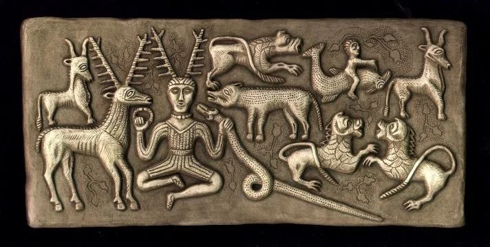 Photo of section of the Gundestrup cauldron, an ancient silver bowl from the early Roman Iron age found in Denmark. Depicts various animals including goats, lions, a tiger, a bird, and a snake, along with a human figure with antler-like horns.