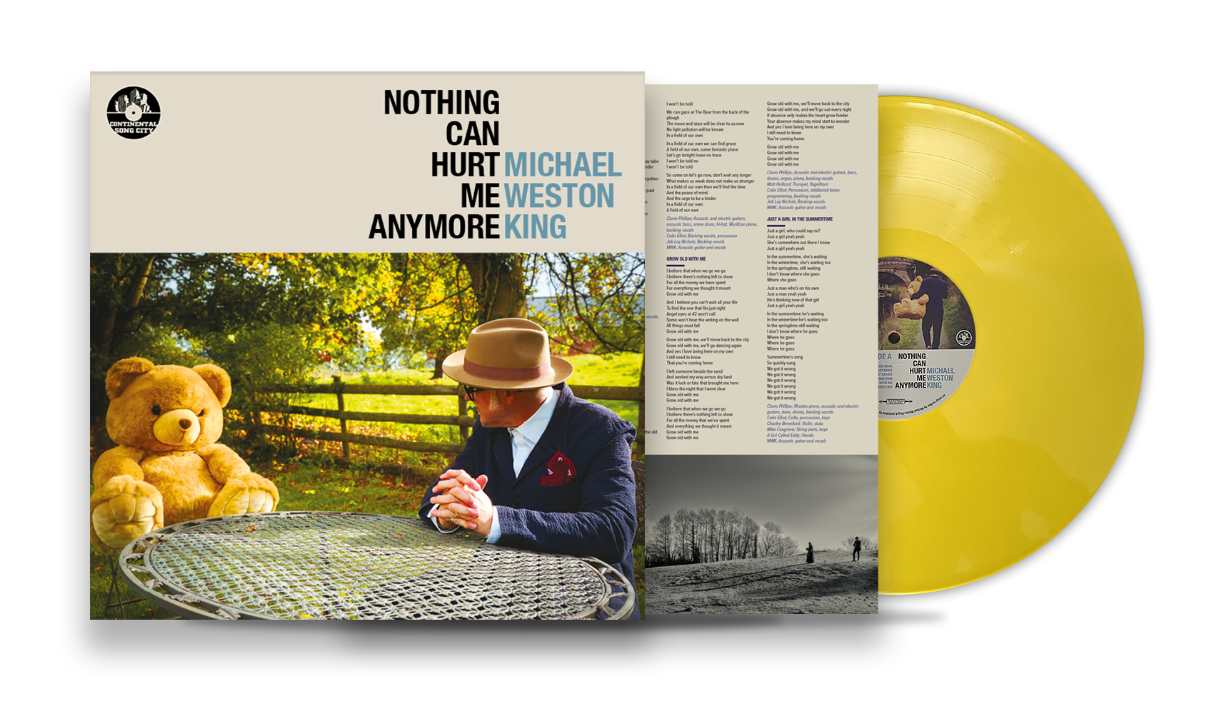 Yellow vinyl record with album cover and lyric sheet; album cover features a man in a dark suit and fedora sitting at a table outdoors with a teddy bear, in a park setting with trees and a fence.
