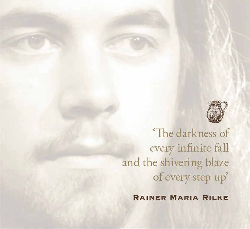 Close-up of a man's face with a beard and long hair, overlaid with a quote and a small illustration of a pitcher.