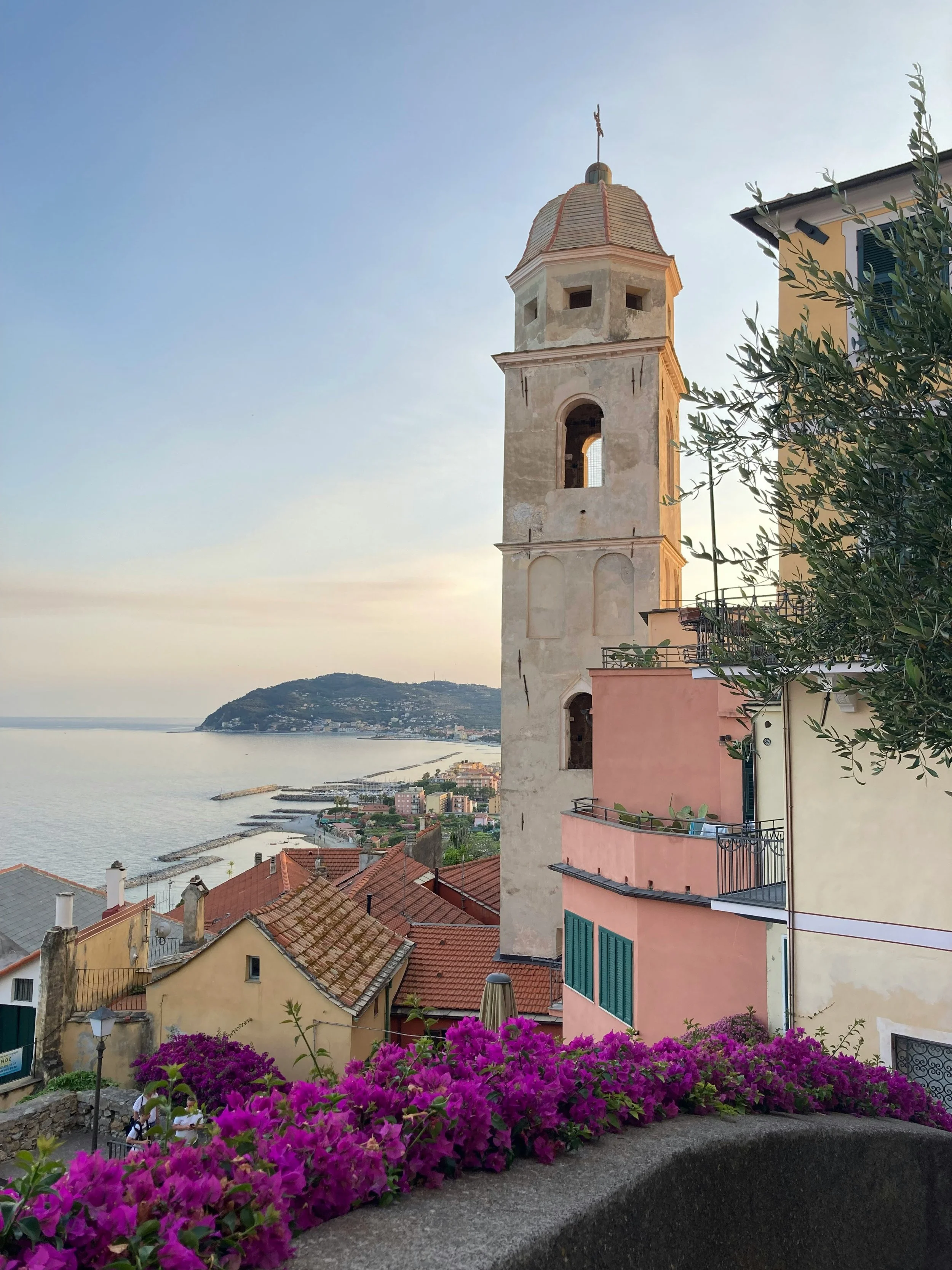 View of a coastal town on the Italian Riviera, could be Camogli, Rapallo or another small town with colorful buildings, a church tower, during sunset.
