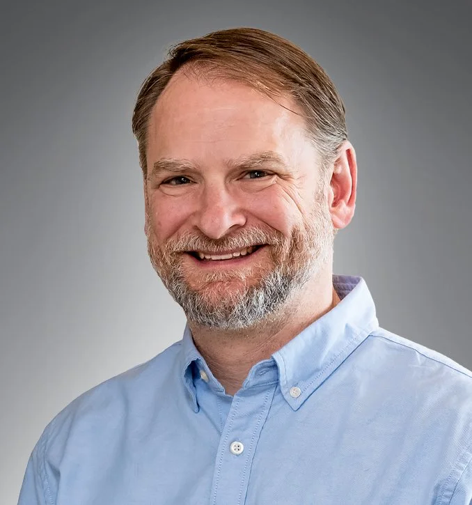 man with blue shirt and beard