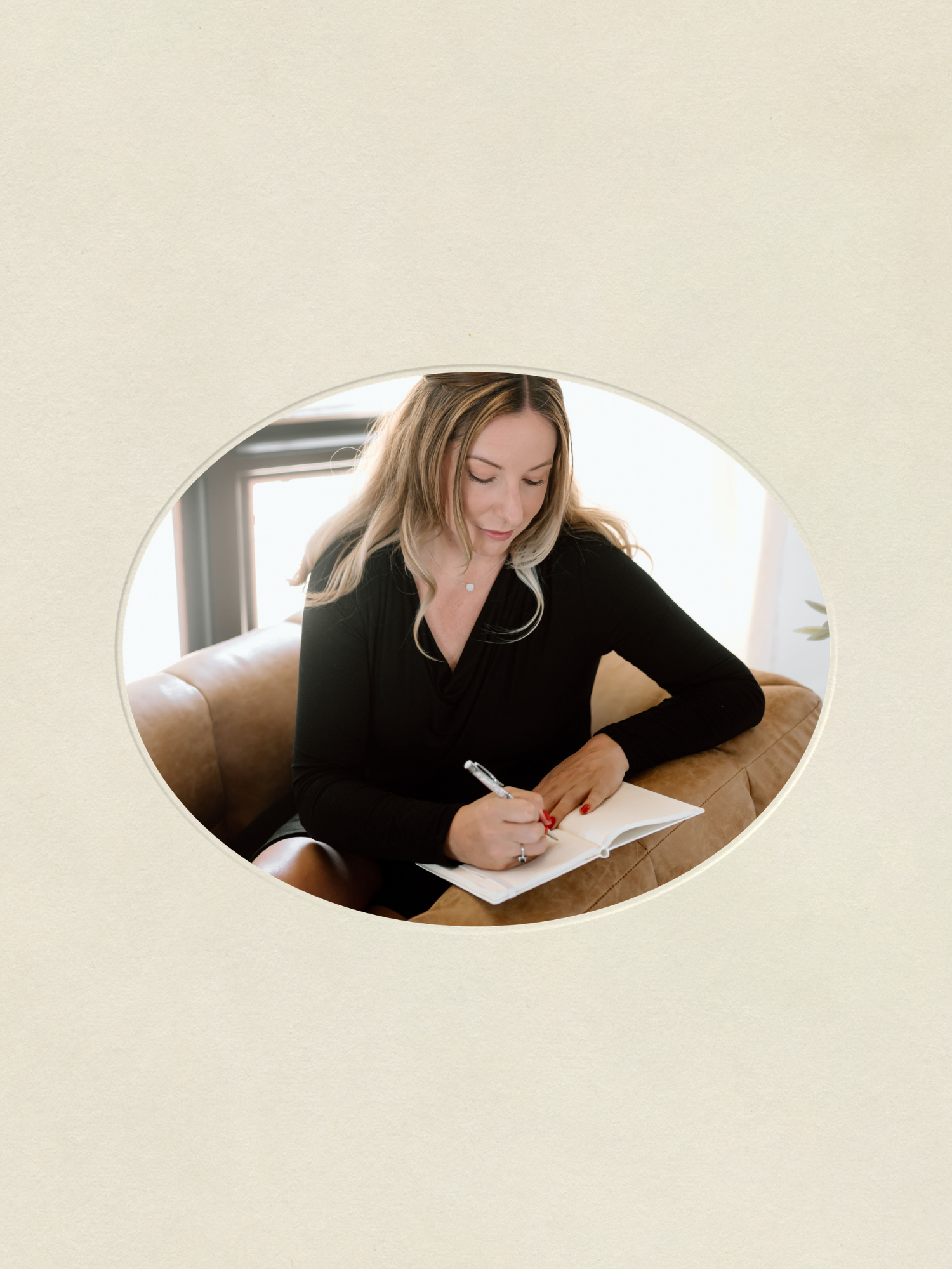 Heather Foidart her philosophical book Reinvention Seasons while sitting on a tan leather couch.