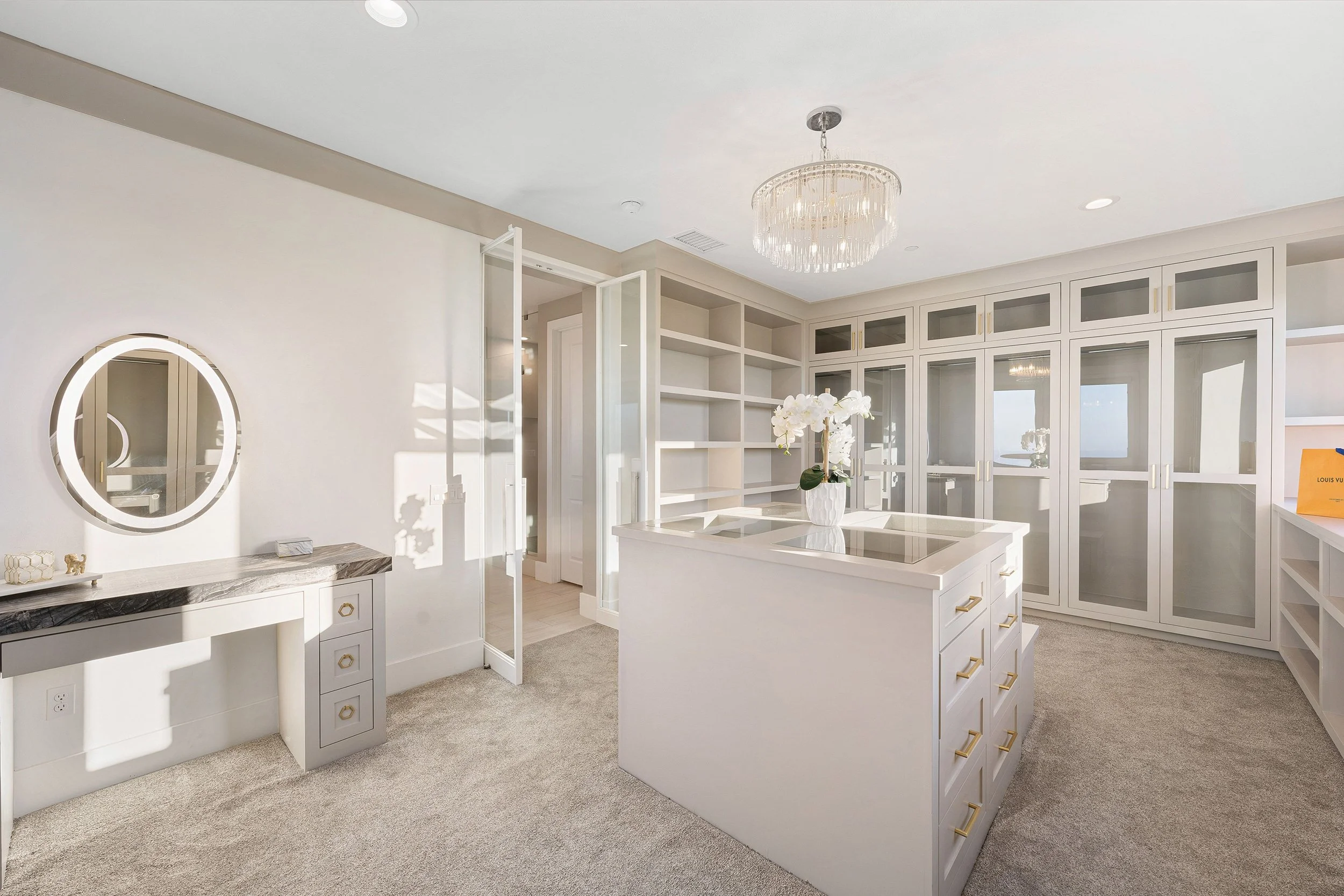 Luxury walk-in closet featuring custom white cabinetry, built-in storage, elegant shelving, and a refined modern dressing space in a high-end home