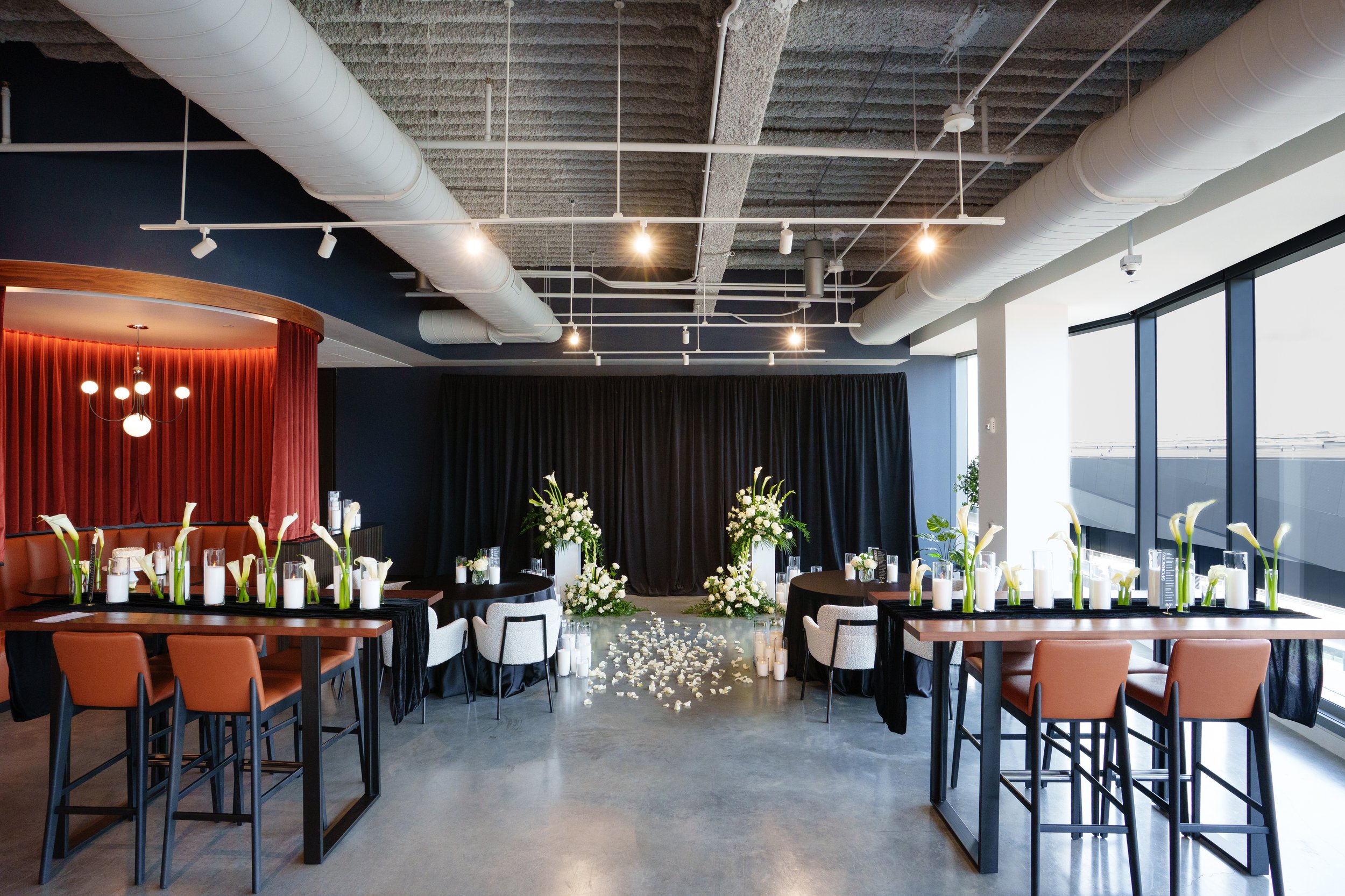 Modern event space styled with Pearl & Ember pearl wax candles, white calla lilies, dramatic black draping, navy accents, and warm cognac leather seating for an elegant wedding or special event. Photography: Nicole Dixon Photographic