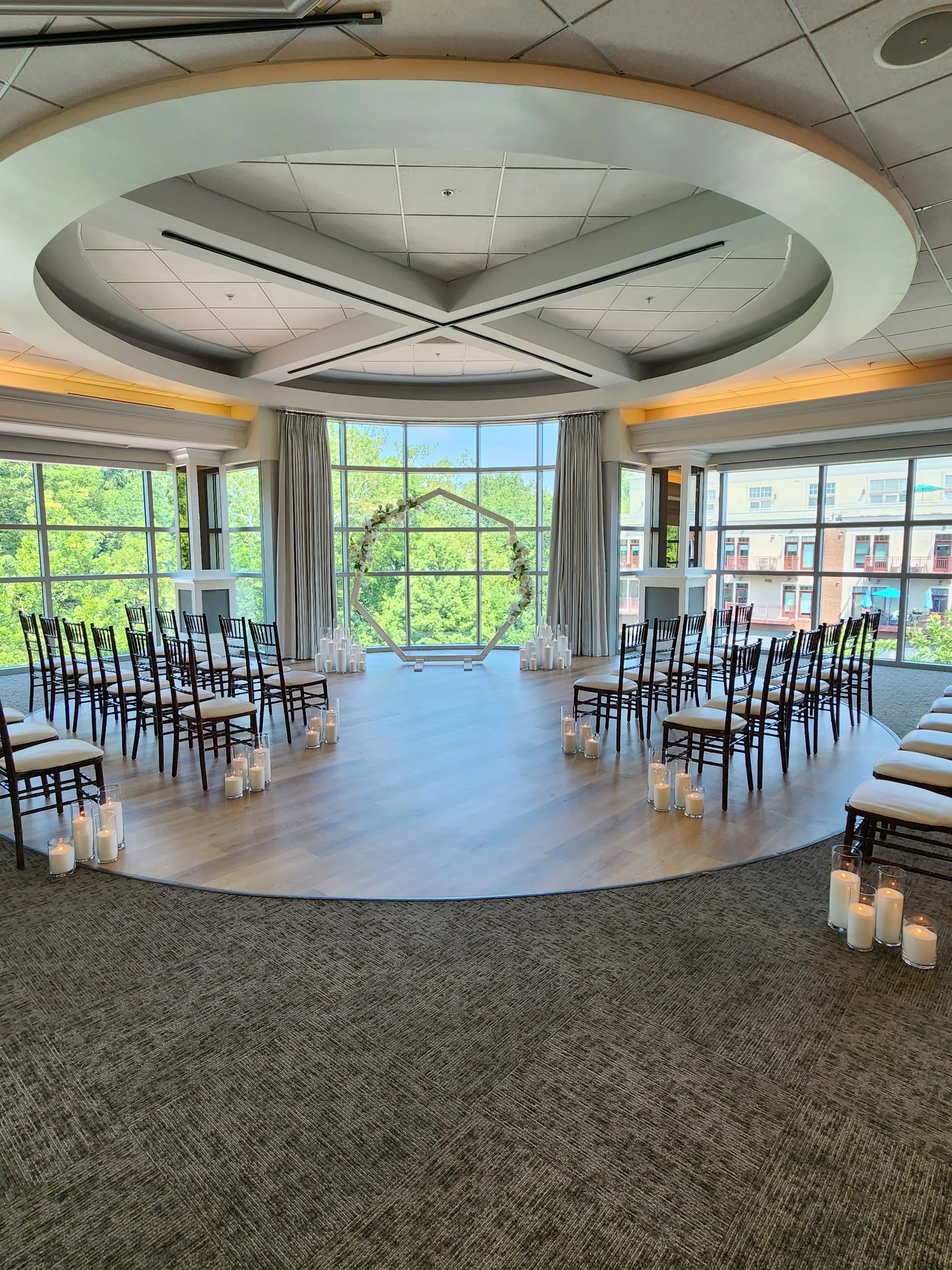 Elegant wedding ceremony with rows of chairs and clusters of Pearl & Ember pearl wax candles lining the aisle and surrounding a hexagonal ceremony backdrop.