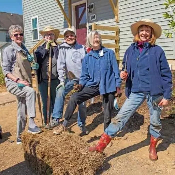 5 people in work clothes helping to build a house