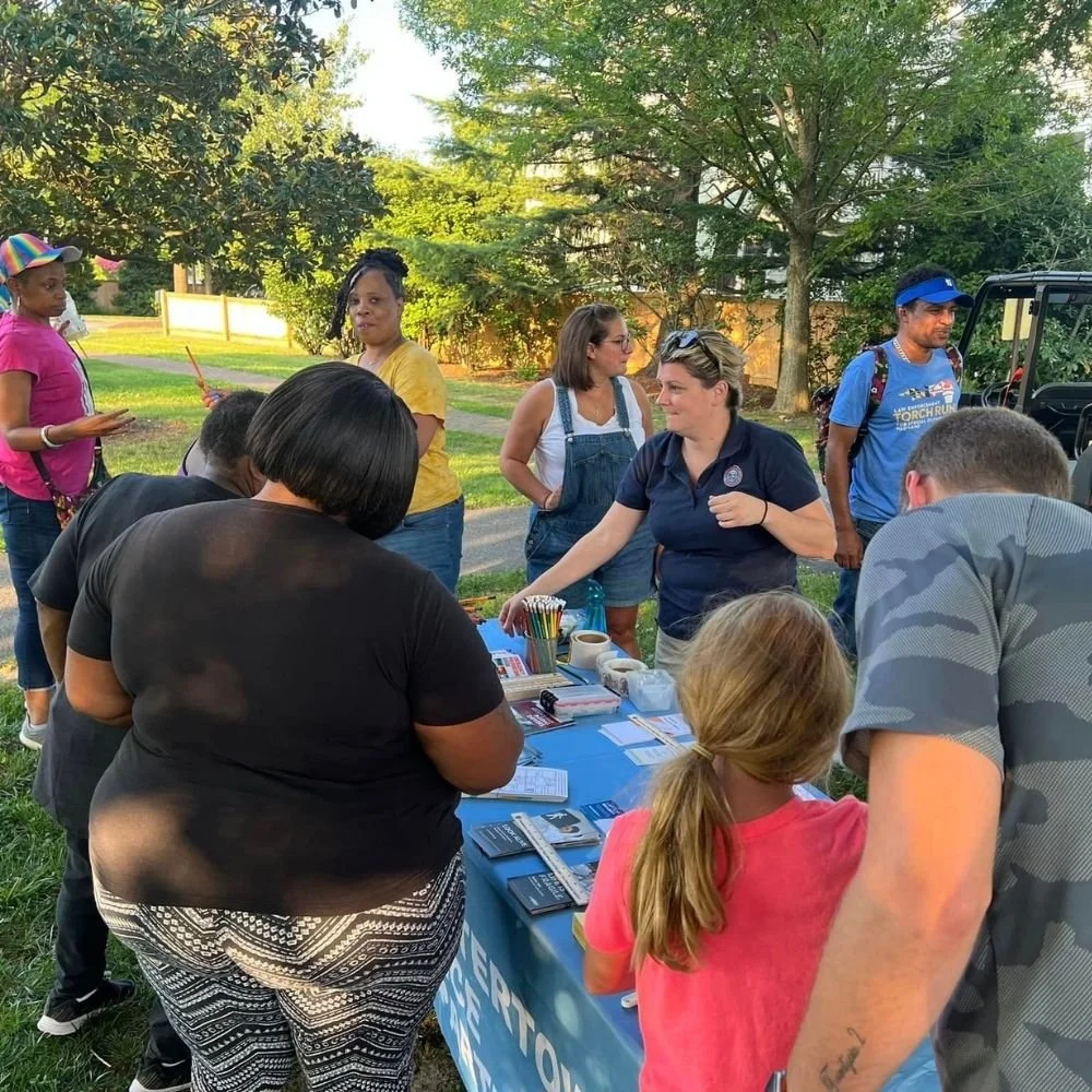 Families and KAH volunteers outdoors at a project table