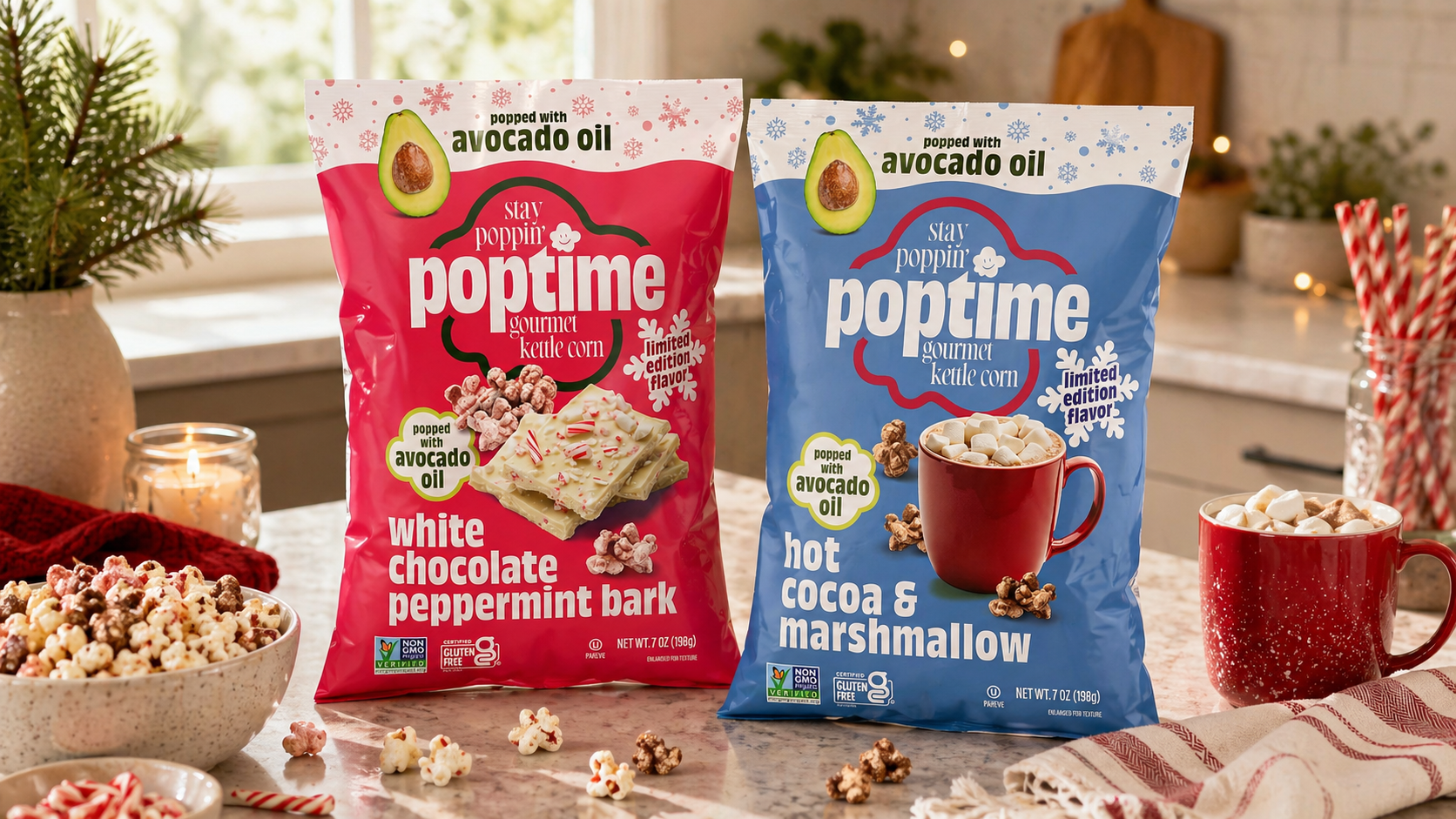 Two bags of Poptime gourmet kettle corn, one in white chocolate peppermint flavor and the other in hot cocoa & marshmallow flavor, placed on a kitchen counter with bowls of popcorn, mugs of hot chocolate, a candle, and festive decorations in the background.