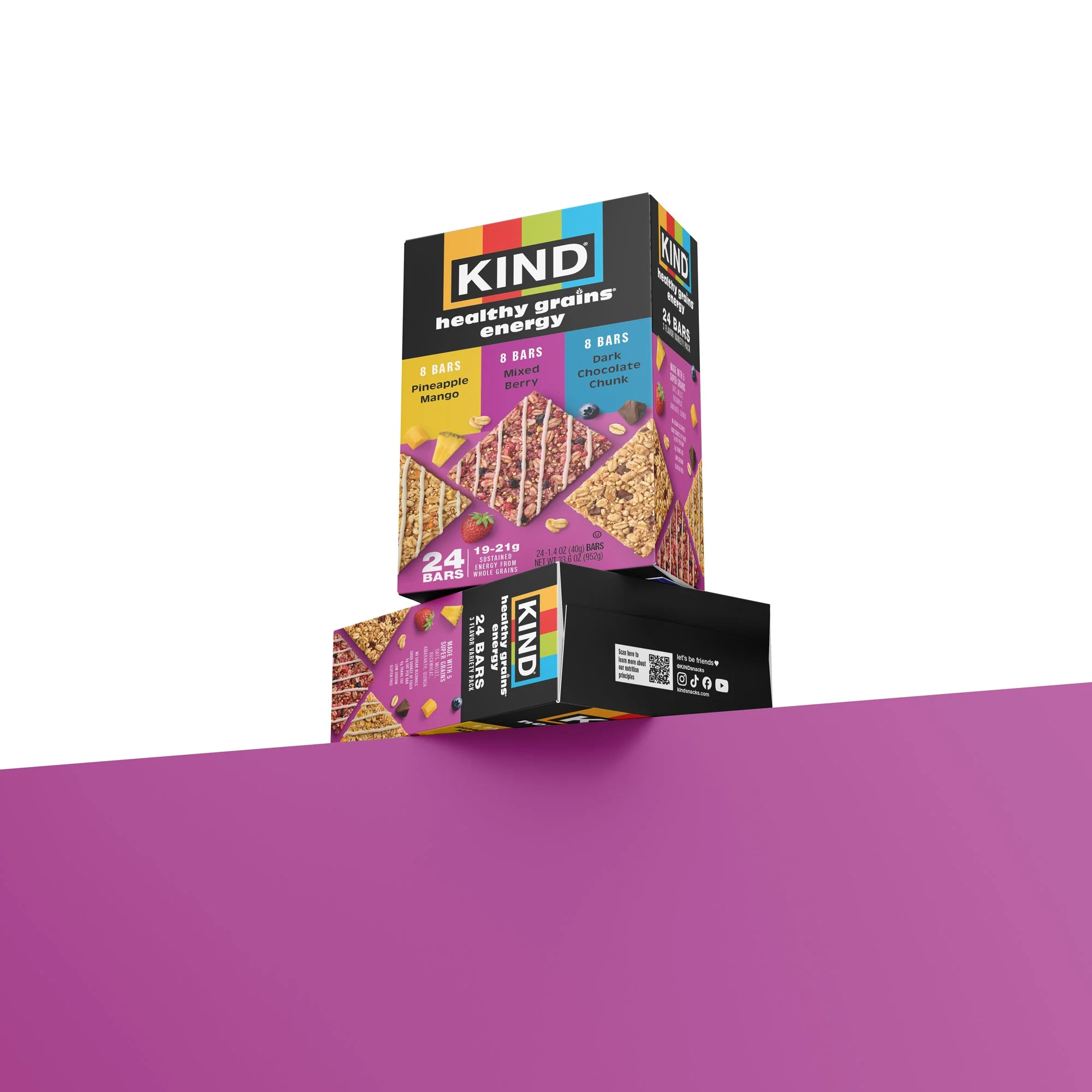 Colorful box of KIND snack bars with flavors pineapple mango, mixed berry, and dark chocolate chunk on a vibrant purple surface.