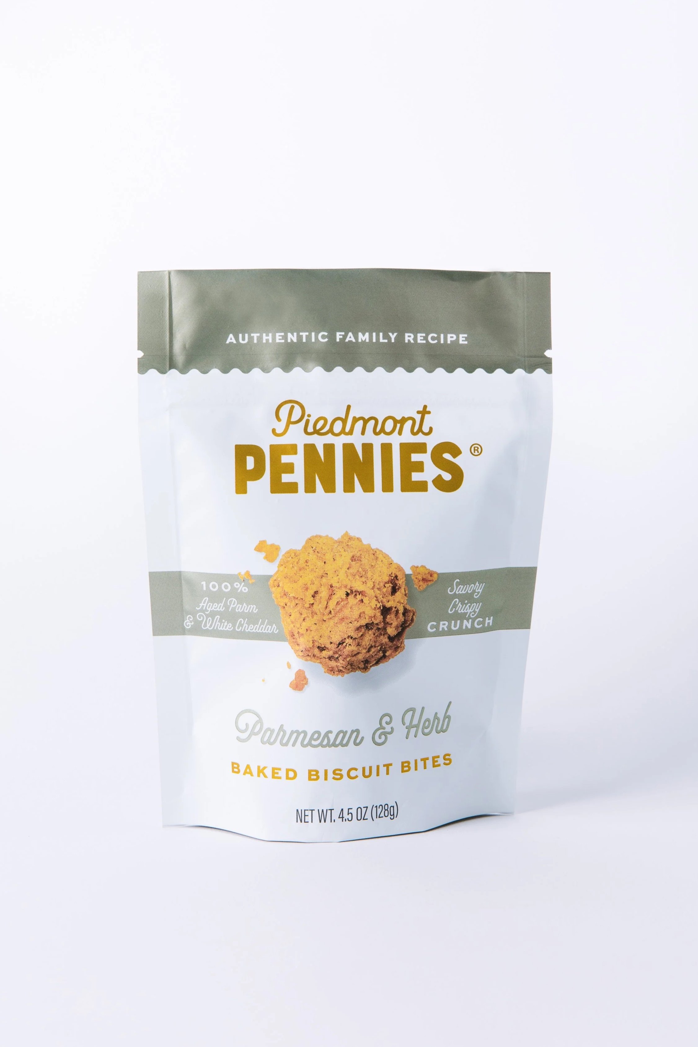 Packaging of Piedmont Pennies baked biscuit bites with an image of a biscuit on the front, described as Parmesan and Herb flavor, emphasizing it is made with authentic family recipe.
