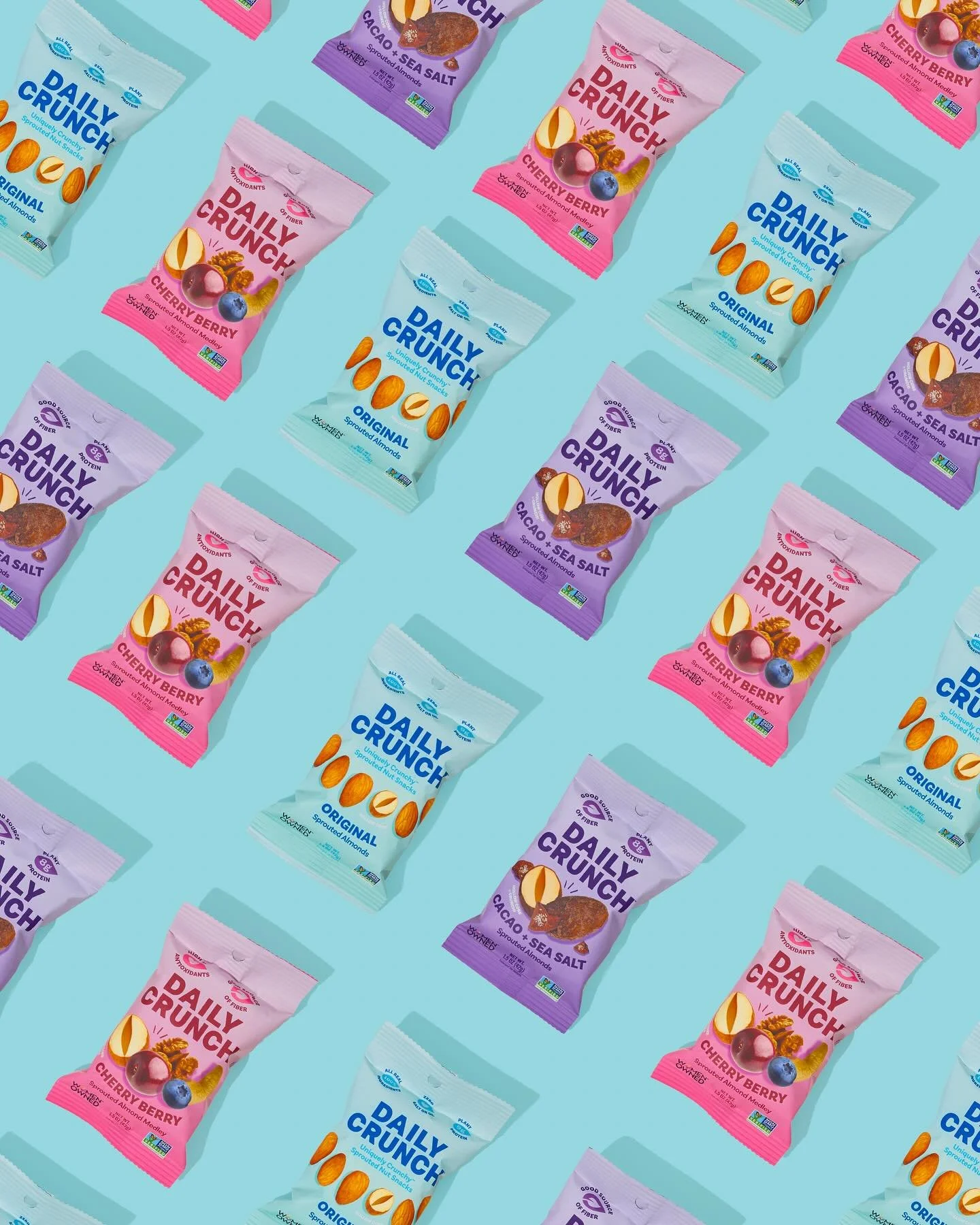 Pattern of Daily Crunch snack bags in pink, purple, and blue colors on a light blue background.