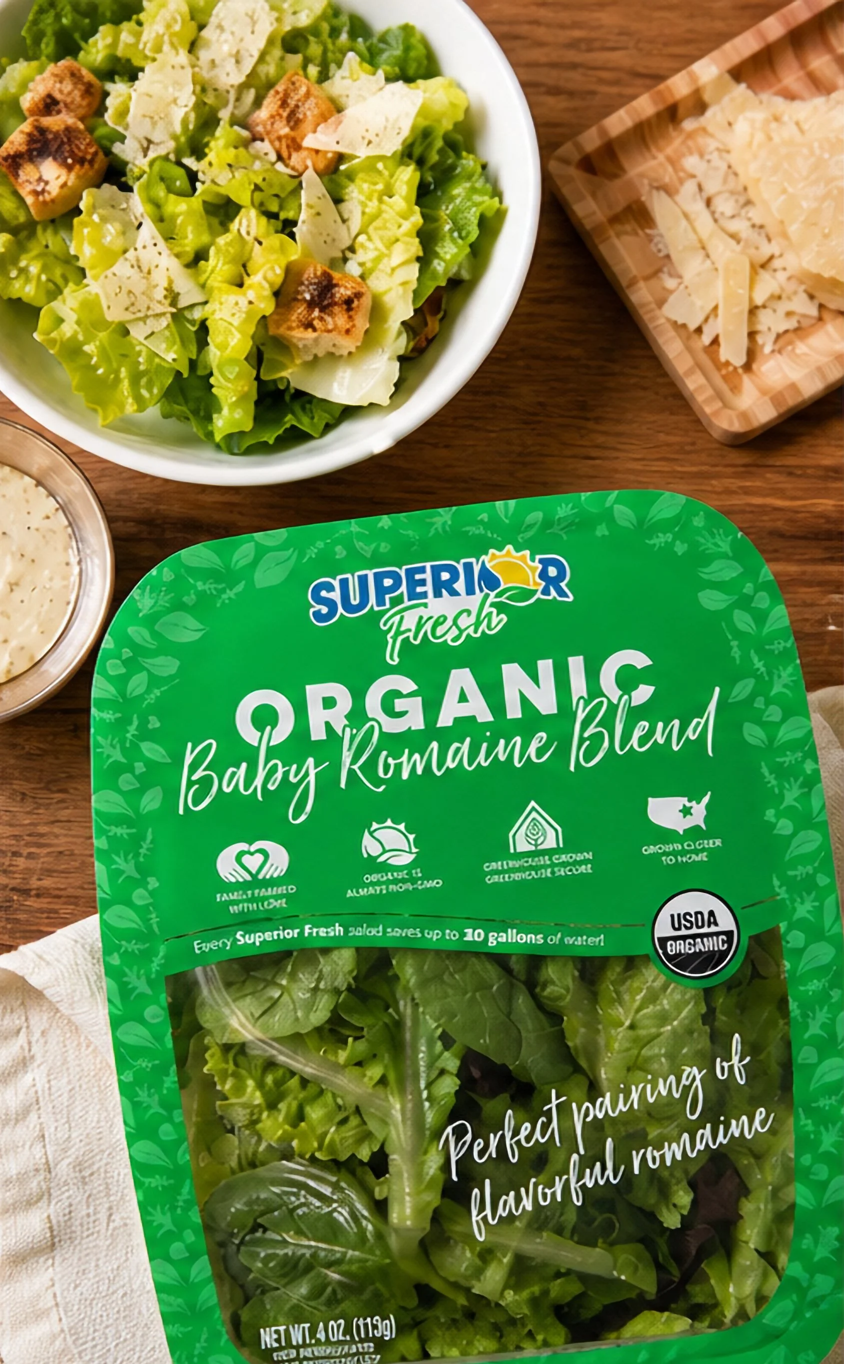 Fresh organic baby romaine lettuce in clear plastic packaging with a green label from Superior Fresh. The label highlights it is USDA organic and ideal for salads, wraps, and cooking.