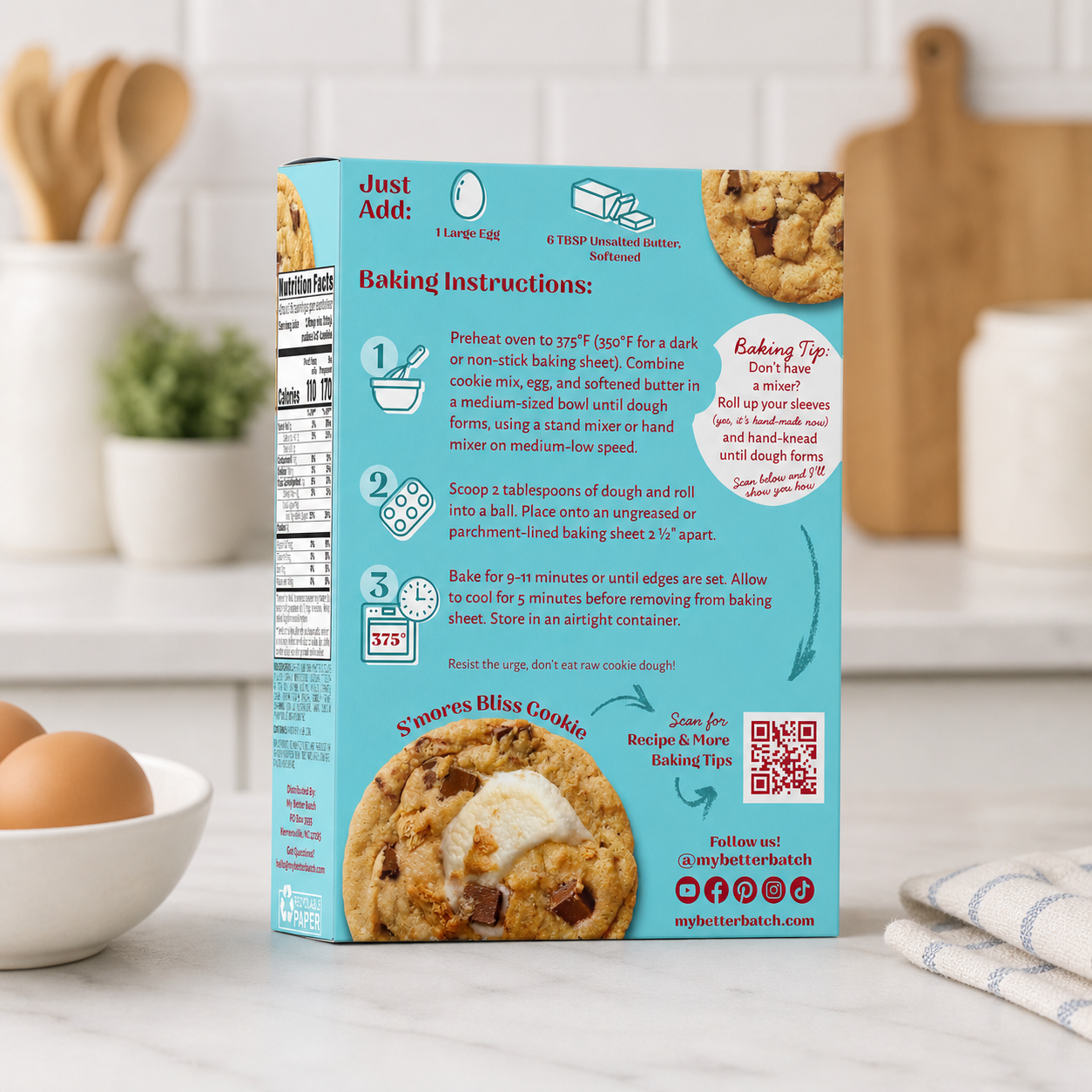 Back of cookie mix box with baking instructions, nutrition facts, a picture of a s'mores cookie, and a QR code on a kitchen countertop.