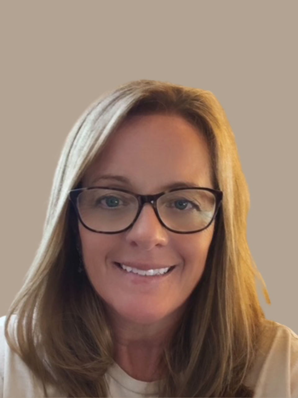 Smiling woman with long brown hair and highlights, wearing a silver earring, in front of a leafy green background. Lisa Reddy, Hospice, home health, revenue, QAPI