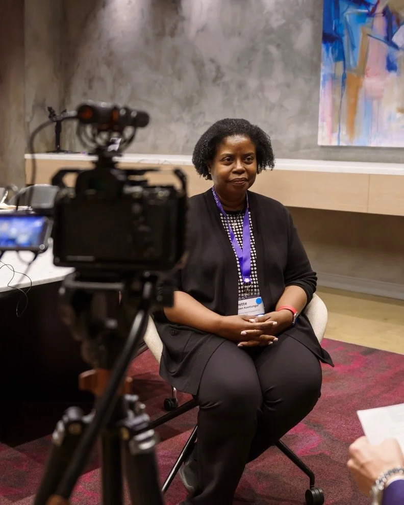 Person holding a smartphone displaying an app with a picture of a black cylindrical device, possibly a wine chiller, on a wooden table with blurred background.
