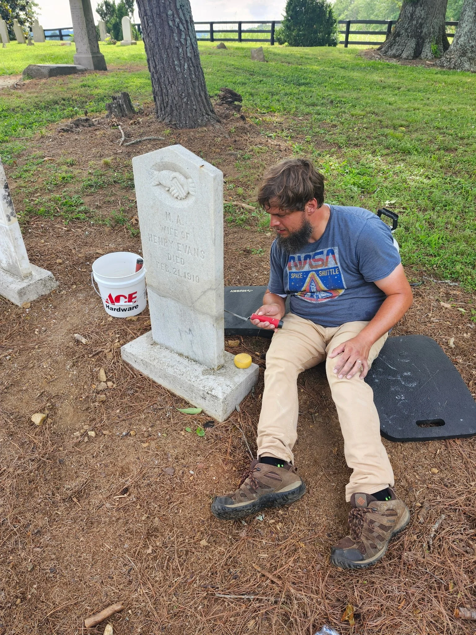 Chase working on the repaired headstone of M.A., wife of Henry Evans