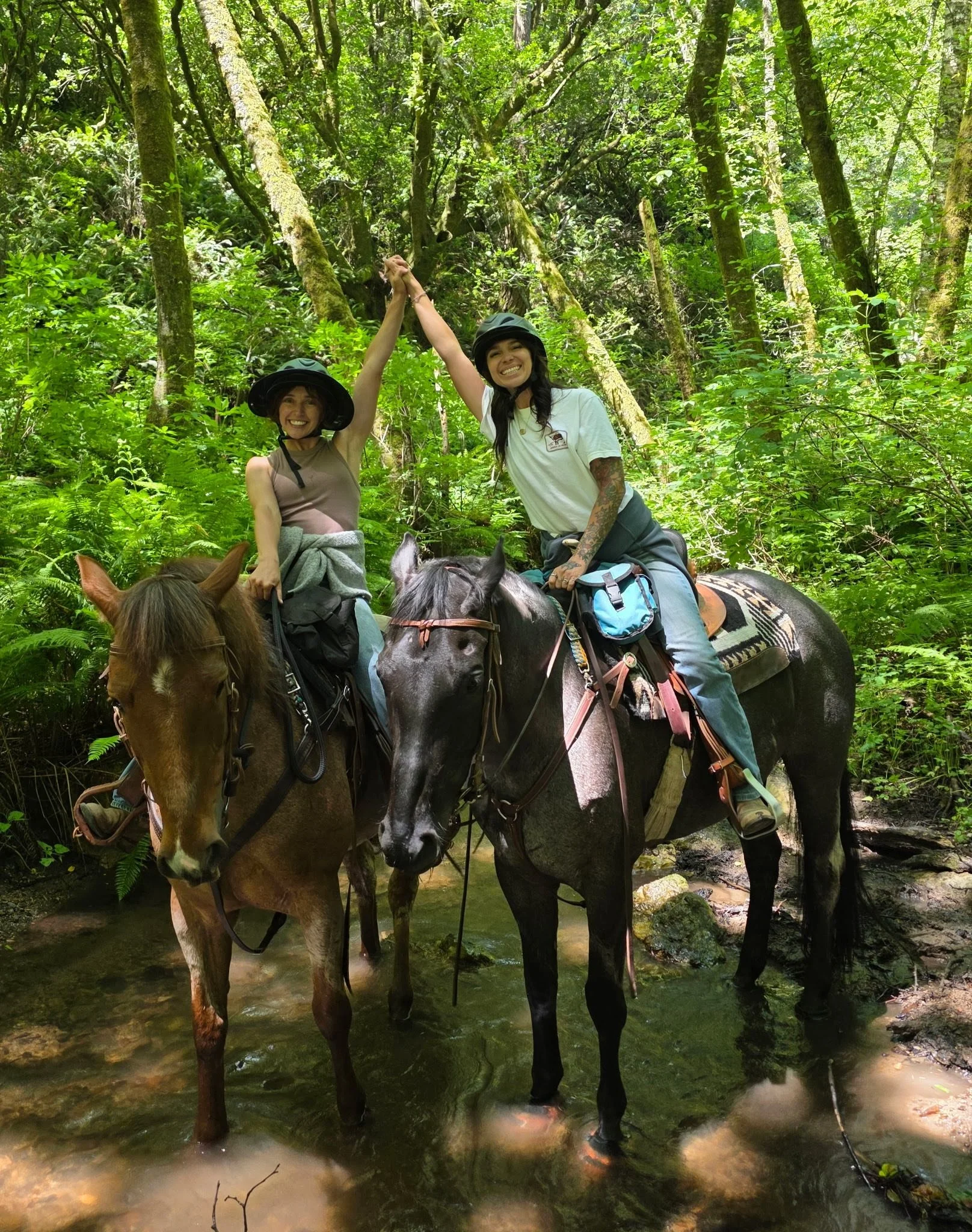 Two riders celebrating on horseback during a trail ride at The Gentle Cowgirl in Stockdale, TX — scenic trail rides and western horsemanship experiences near San Antonio